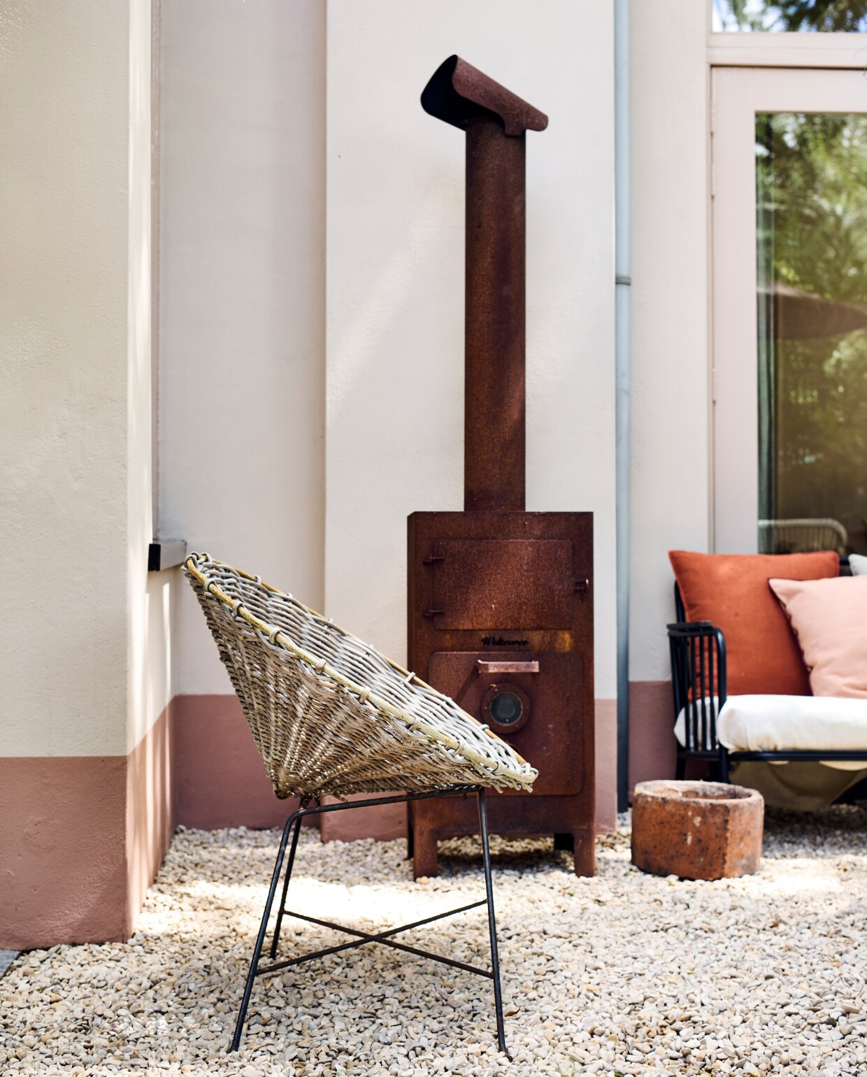 Buitenkachel Weltevree, stoel Kave Home, tuinbank Kwantum. Muurverf boven Cotton en streep onder Burnt Sienna van Autentico Paint, lakverf kozijnen Roman Plaster van Little Greene. vtwonen tuinspecial 10 | Fotografie Sjoerd Eickmans | Styling Liza wassenaar