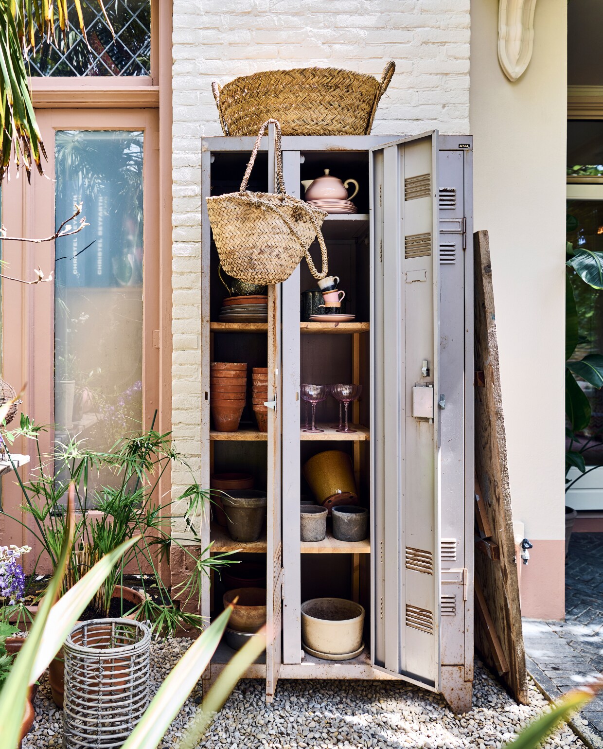 Papyrusplant. De vintage lockerkast stond in eerdere huizen binnen, nu als opberger buiten. Manden Household Hardware. Theepot en borden antiek. Koppen en schotels HKliving. Glazen Sissy-Boy, witte pot vtwonen. vtwonen tuinspecial 10 | styling Liza wassenaar | fotografie Sjoerd Eickmans