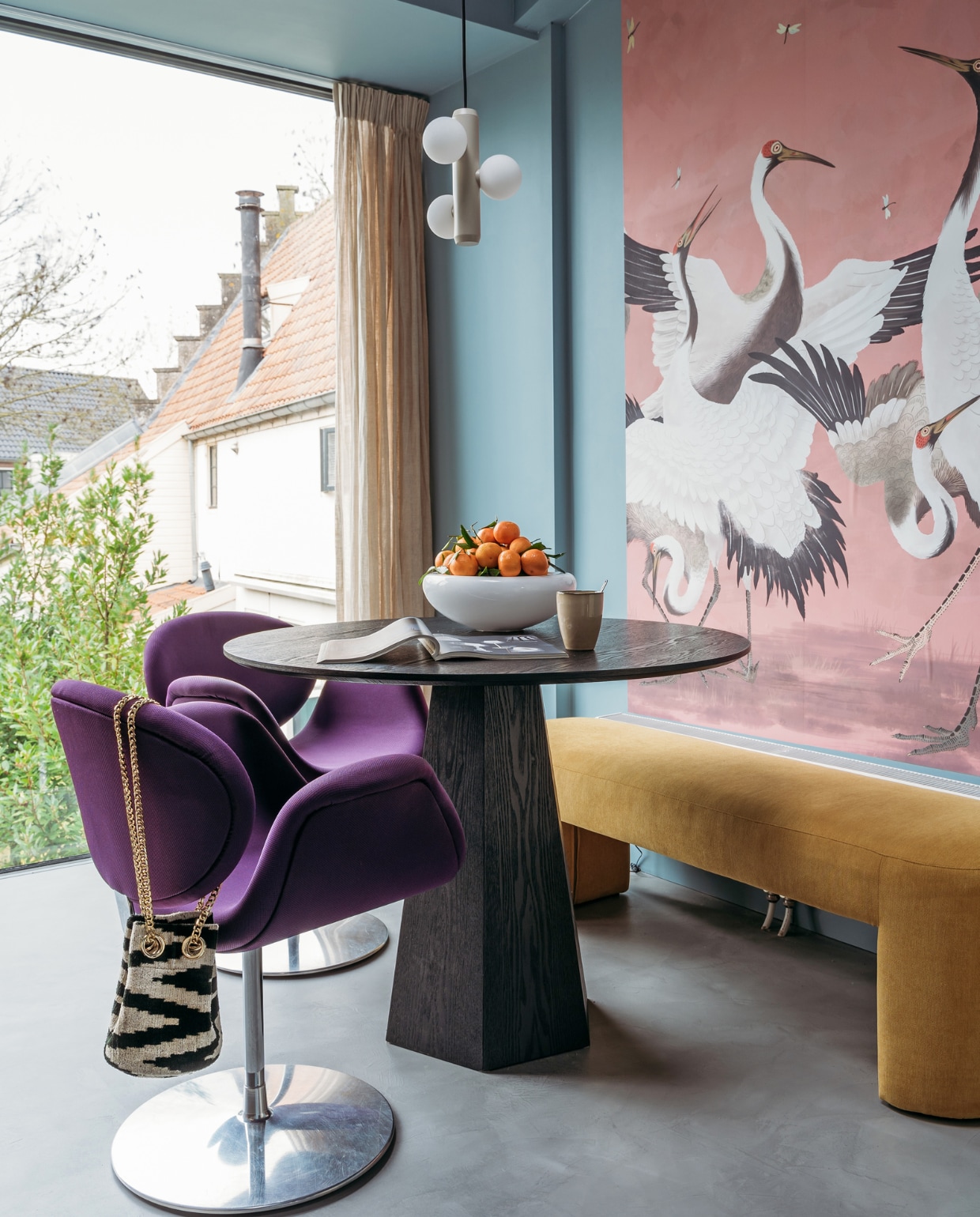 Verf muur en plafond R0.10.60 van Sikkens. Herkomst linnen gordijnen onbekend. Behang Heron Removable Peel and Stick Mural van AmsterdamElement. Tafel Pilar van Zuiver. Bank Lobby Bench van HKliving. Stoelen Little Tulip van Artifort via Marktplaats. Fruitschaal Eva Solo. Schaal Smiley van Tools Design. Beker Xenos. Hanglamp Kaktee van Fést. Tas Rough Studios. Vloer Cem-Line Micro van Loos Betonvloeren. vtwonen 03-2021 | Productie Coco Features | Styling Laurien Deken | Fotografie Inge Korver