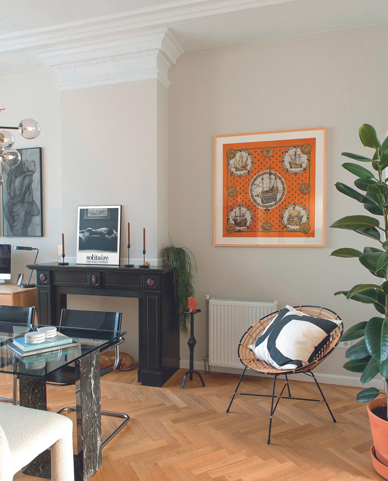 Tafel Cattelan Italia, rieten stoel cadeau, kussen H&amp;M Home. Kaarsenstandaard en stoelen Marktplaats. Ingelijste Hermèssjaal van grootmoeder Mick. Kandelaars en bureaulamp Ikea. Foto Solitaire van Naomi Stanley, onderzetters uit Griekenland. Bureau en bankje Made. Muurverf Skimming Stone van Farrow &amp; Ball. Overig onbekend. vtwonen 05-2024 | productie De Binnenkijkers | styling Jeske Weel | fotografie Caroline Coehorst