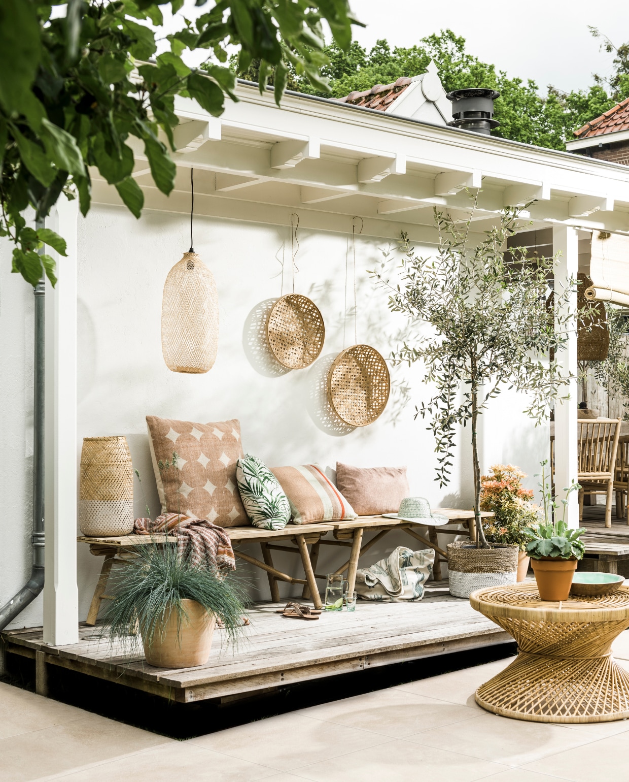 Hanglamp l’Etoile Bamboo € 169,- (l’Etoile Conceptstore). Bamboe schaalmanden vanaf € 19,95, bamboe windlicht € 49,95, celadonkleurig houten schaaltje € 69,-, groene glazen karaf € 14,99, glaasje € 3,49, rechthoekig kussen zacht terra van By Mölle € 59,95 (Nijhof). Bamboe bankjes van Tine K Home per stuk € 219,-, rotan tafel € 289,- (www.vtwonen.nl). Groot kussen € 49,99, gestreept kussen € 29,99, tas met cactusdessin € 34,99 (Sissy-Boy). Terracotta pot € 16,99 (Intratuin). Pandanmand naturel-wit € 57,50 (Manggis Living). Buitentegels Duostone in de kleur Desert Walnut, 60x60x4 cm, per m² € 75,- (www.vtwonenbuitentegels.nl). Olijfboom (Planta Groencentrum). Overige planten (tuincentrum). Slippers (Van Haren). vtwonen 07-2016 | Styling moniek visser | Fotografie sjoerd eickmans
