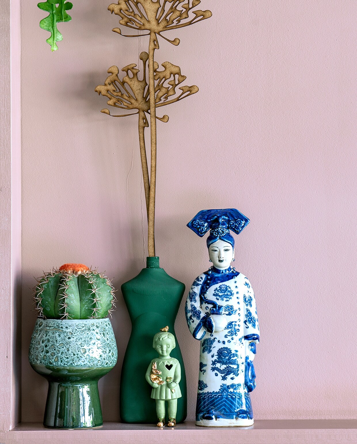 Chinees beeld @kastjenaardemuur, vaasfles Foekje Fleur, keramieken poppen Lammers &amp; Lammers, houten bloem @cut.spul, groene bloempot Henny’s Home, muurverf Sulking Room Pink van Farrow &amp; Ball. Overig kringloop of onbekend. vtwonen 05-2024 | fotografie Ton Bouwer