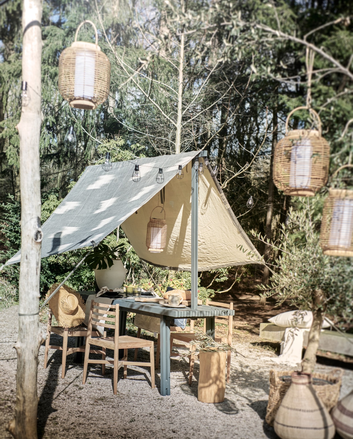 Tafel met zonwering prijs op aanvraag (com-anders.nl). Doek Metre Grand Bazaar, 130 cm (b) € 87,- (loggerewilpower.com). Witte pot met oren Sava € 169,-(urbannatureculture.com). Lantaarns van Luca Lighting, 18,5x29,5 cm (Øxh) € 37,99 en 26x30 cm (Øxh) € 35,99, lichtsnoer Party Lights van Luca Lighting, 315 lumen € 39,98 (vtwonen.nl/shop). Duurzaam teakhouten kruk € 740,- (dacks.nl). Houten stoelen, per stuk € 249,-, houten servetring, set van 2 € 7,99, servet, set van 2 € 12,99, zwart bord € 14,99, zwart bakje € 7,99, wit bord met zwart lijntje € 12,99 witte plaid op bank rechts € 29,99, zwart bestek, 16-delig € 89,99 (hm.com). Beige loper, set van 2 € 29,99, grijs glas met lijntje € 5,99, mand met hengsels € 69,99 (zarahome.com). Broodplank prijs op aanvraag, gestreept kussen op achtergrond van Libeco € 168,-, mand met streep Binga kalebas 82 uit Zimbabwe, 42x51 cm (Øxh) € 79,- witte kan prijs op aanvraag, papieren hoed € 21,- (couleurlocale.eu). Blauw kussen op stoel van Designers Guild € 99,- (wva.nl). Overig privébezit. vtwonen 06-2023 | styling Liza Wassenaar | fotografie Sjoerd Eickmans
