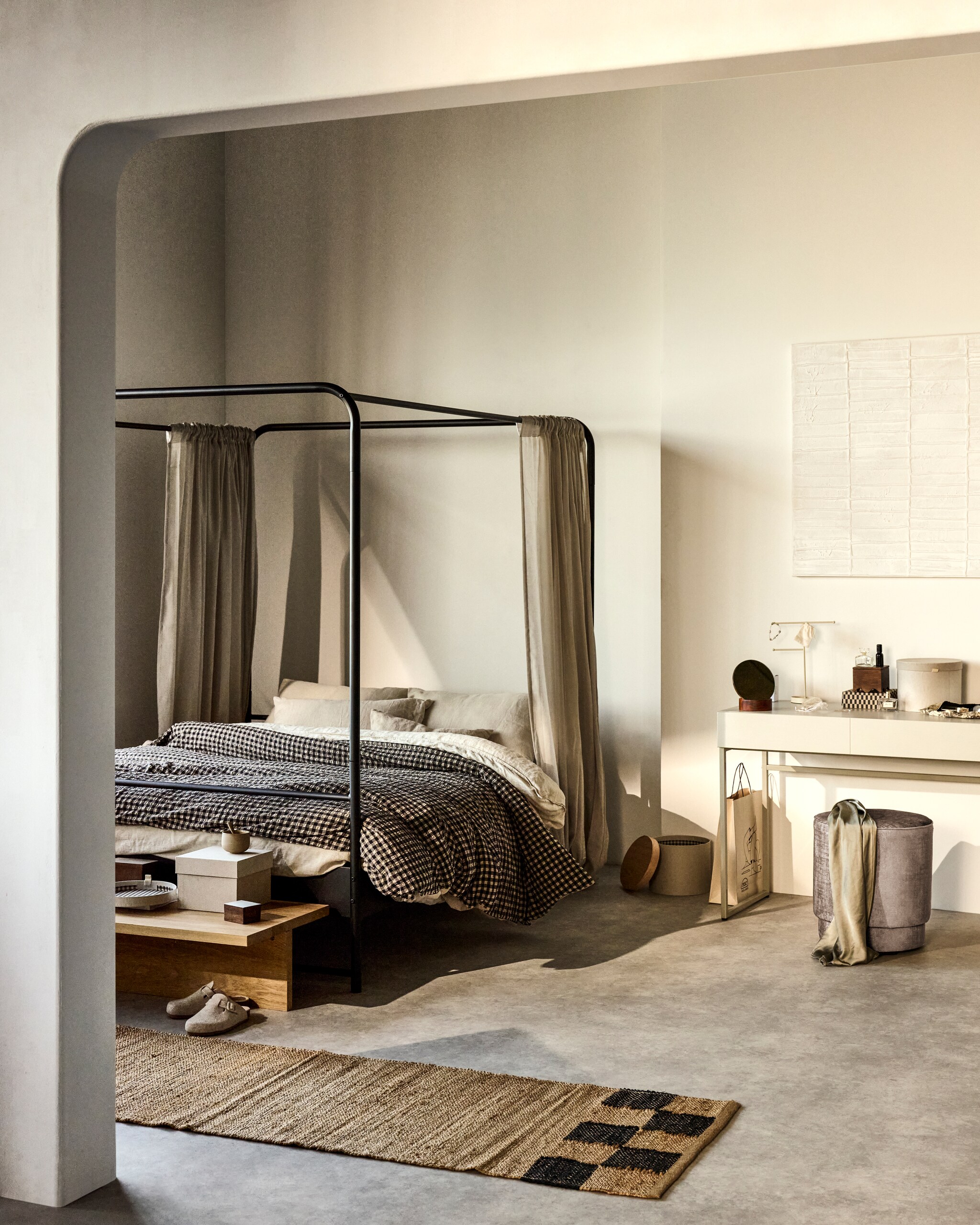 Bed Bunk, metaal in Zwart, 205x165x190 cm (lxbxh) € 399,- (exclusief doek en matras, ook verkrijgbaar in 190x125x206 cm € 349,- en 190x95x206 cm € 279,-). Eikenfineer salontafel Angle, 135x49x27 cm (lxbxh) € 469,-. Grenenhouten bureau Basic in Mist, 150x50x76 cm (lxbxh) € 399,-. Poef Pearl in stof Melange Naturel, 40x45 cm (Øxh) € 129,-, verkrijgbaar in meerdere stoffen.M.m.v. vtwonen.nl/shop (schilderij van Kave Home), velv.nl (kussens Eve en Pure, mok), zarahome.com (dekbedovertrek, geruit dekbedovertrek, sloffen, doosje met deksel), hm.com (vloerkleed, sieradenrek, doosje met geschulpte rand, gordijnen), bloomingville.com (spiegel Rita), ikea.nl (kartonnen dozen). Overig privébezit. vtwonen 07-2024 | styling Sanne Ketelaar | fotografie Sjoerd Eickmans