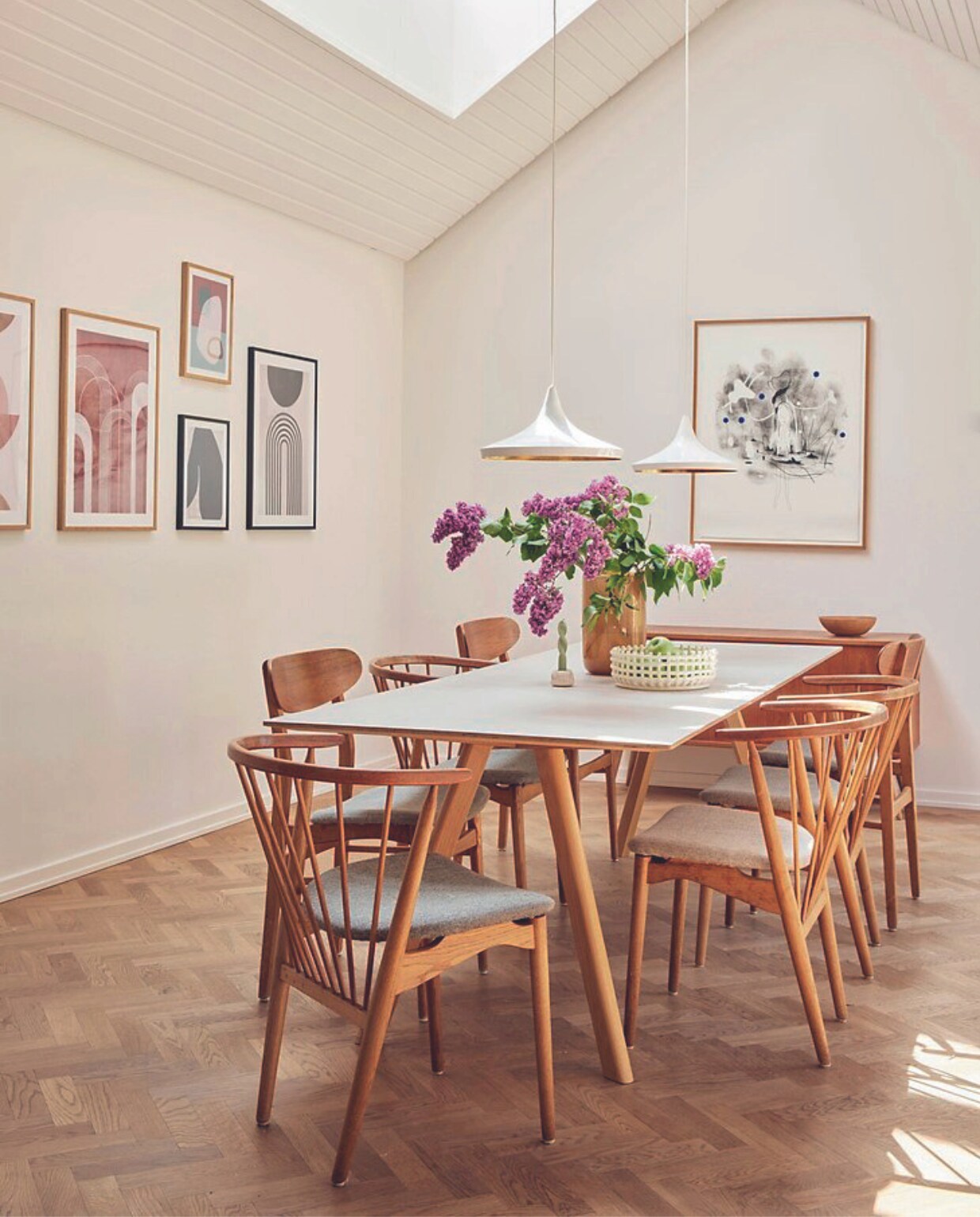 Eettafel Hay, stoelen Sibast Furniture, plafondlampen Tom Dixon, posters Desenio, zwart-witte litho Kathrine Ærtebjerg, vaas H&amp;M Home, gevlochten schaal Ferm Living. vtwonen 06-2024 | fotografie Christina Kayser Onsgaard | styling Rikke Graff Juel