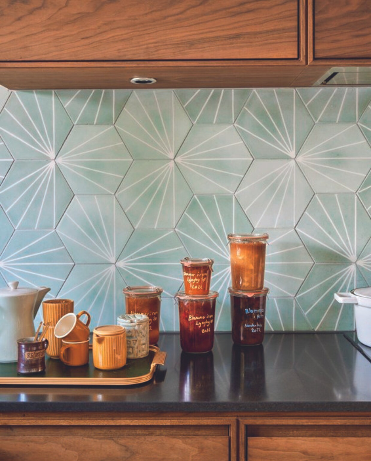Keuken Koch, wandtegels MarrakechDesign, dienblad Kaymet, bruine geëmailleerde kopjes Fabelab, overige kopjes Flying Tiger, groene jampot Gitte Svarre Jensen, theepot erfstuk. vtwonen 06-2024 |styling Rikke Graff Juel | fotografie Christina Kayser Onsgaard