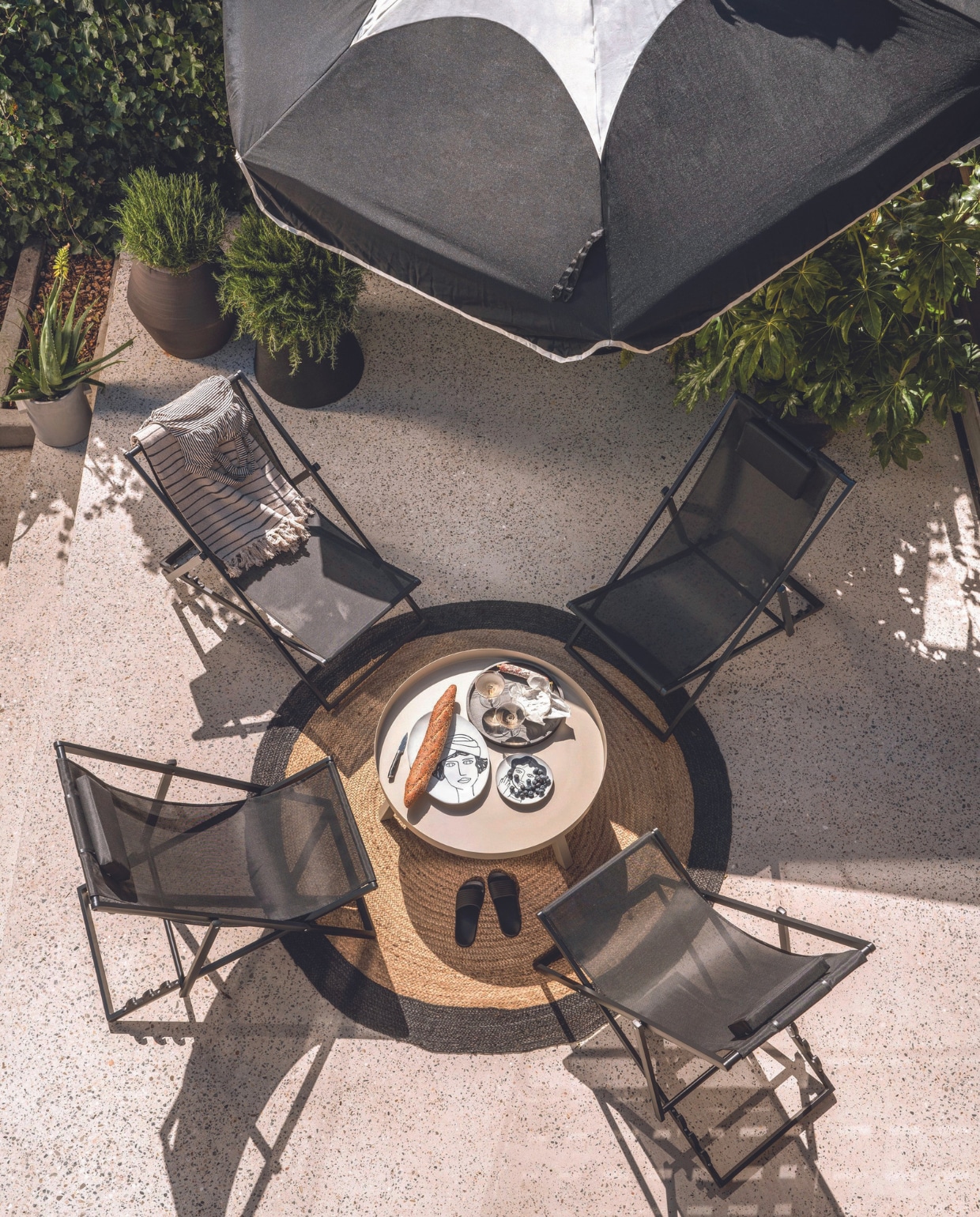 Strandstoelen Esper van Exotan, aluminium en textiel, 61x102x74 cm (bxdxh) per stuk € 109,-, metalensalontafel Sunny van Woood, 80x35 cm (Øxh) € 99,95, houten dienblad € 99,99, keramieken borden La Mère vanaf € 21,- en lage betonnen en hoge steengoed potten van Serax van €  25,50 tot € 381,-, plaid Eia van Bloomingville, gerecycled katoen, 160x130 cm € 23,99, champagneglazen Ripple van Ferm Living, set van 2 € 35,-(vtwonen.nl/shop). Polyester parasolSunshady, 300 cm (Ø) € 399,- met stalen parasolvoet Base € 399,- (fatboy.com). Juten vloerkleed Rondo, 180 cm (Ø) € 85,- (hetkabinet.nl). Badpak (marliesdekkers.nl). Slippers (hema.nl). Overig privébezit. vtwonen 07-2024 | styling Marianne Luning en Kelly van Gendt | fotografie Stan Koolen