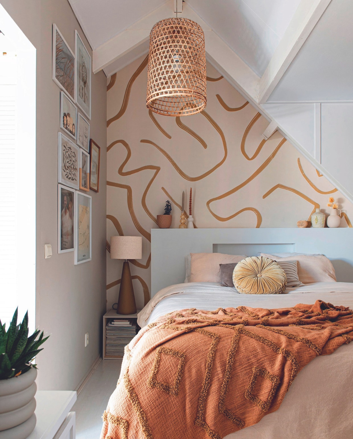 Behang Belarte Studio, hanglamp By Noth, tafellamp Zara Home. Kandelaars Kwantum en Present Time. Plaid HKliving. Kussens Kwantum en Nox Studio Interiors. Hoofdbord zelfgemaakt, dekbed H&amp;M Home, sprei HKliving, wandkleur Mushroom van Lab Paint, bloempot Intratuin zelf geverfd. vtwonen 06-2024 | productie De Binnenkijkers | styling Jeske Weel | fotografie Caroline Coehorst