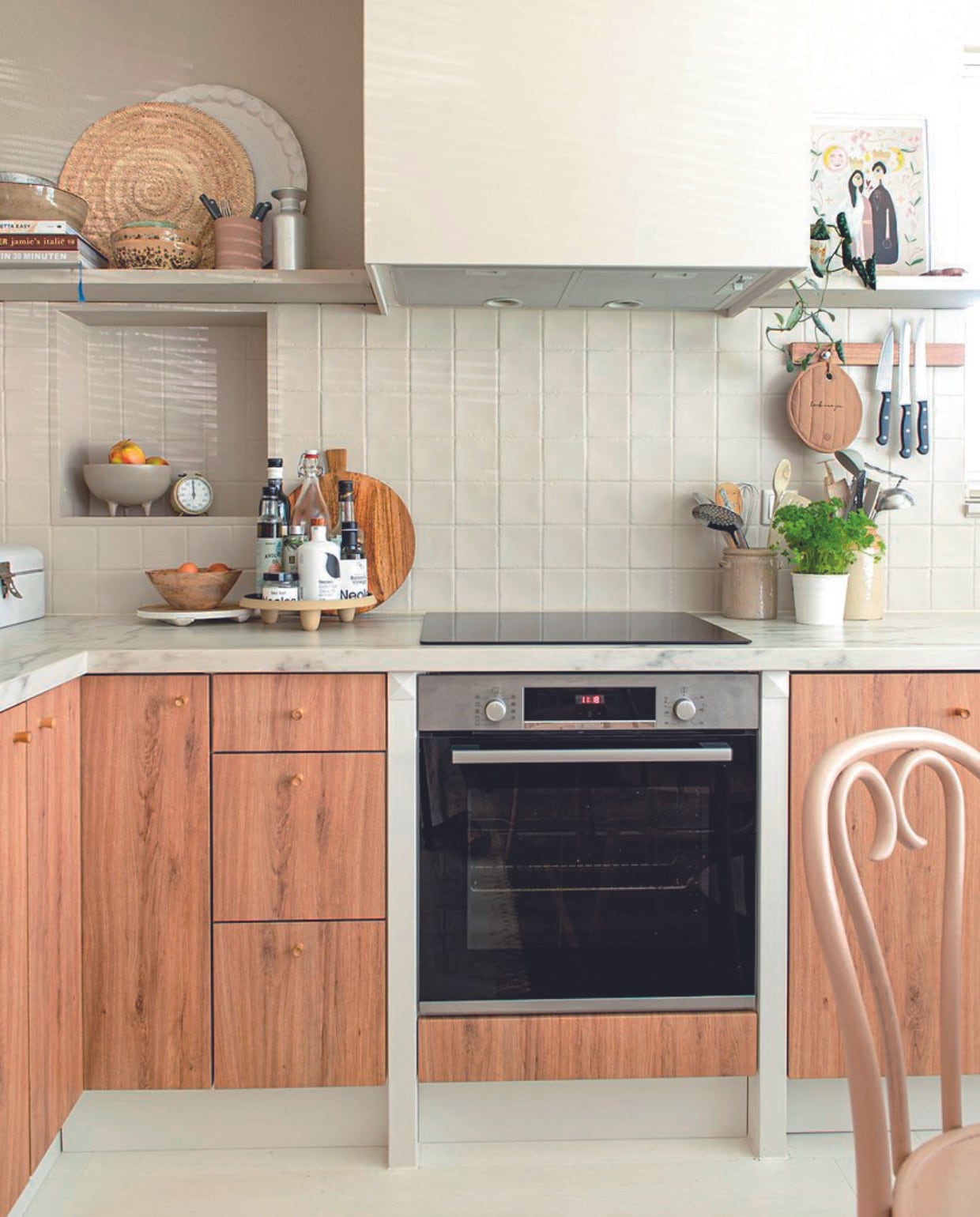 Keuken gewrapt door wrapjekeuken.nl. Tegels en muur geschilderd in Mushroom van Lab Paint. Olijfolieflessen Neolea, plateau Sissy-Boy, broodplank HKliving, messenhouder Blokker, pannenlap Zusss, schaaltjes op plank HKliving, schilderij Wewonderwall, oven Bosch. vtwonen 06-2024 | productie De Binnenkijkers | styling Jeske Weel | fotografie Caroline Coehorst