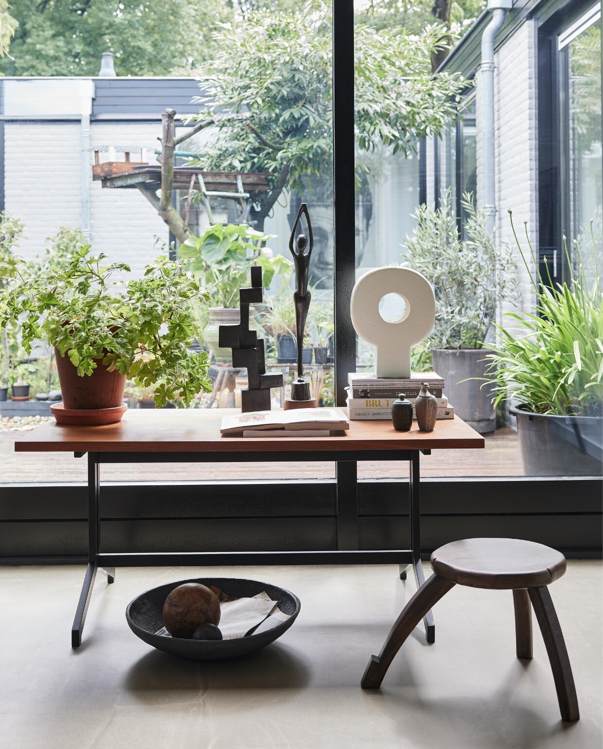 Vintage salontafel Eeka van Friso Kramer en Coen de Vries, 120x65x53,5 cm (lxbxh) € 175,- (neeflouis.nl). Keramische tafellamp Tree € 99,95, zwart metalen object Aosta € 119,-, stenen schaal Ateljé € 22,95, mangohouten plantentafel, 50x28 cm (Øxh) € 159,- (urbannatureculture.com). Beeld, souvenirs, houten bal en overig privébezit. vtwonen 10-2023 | styling Fietje Bruijn | fotografie Alexander van Berge