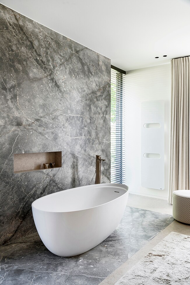 In de badkamer steelt marmer Fioro di Bosco de show. Het badkamermeubel is van Antoniolupi, het kraanwerk van Hansgrohe. Jonah Samyn