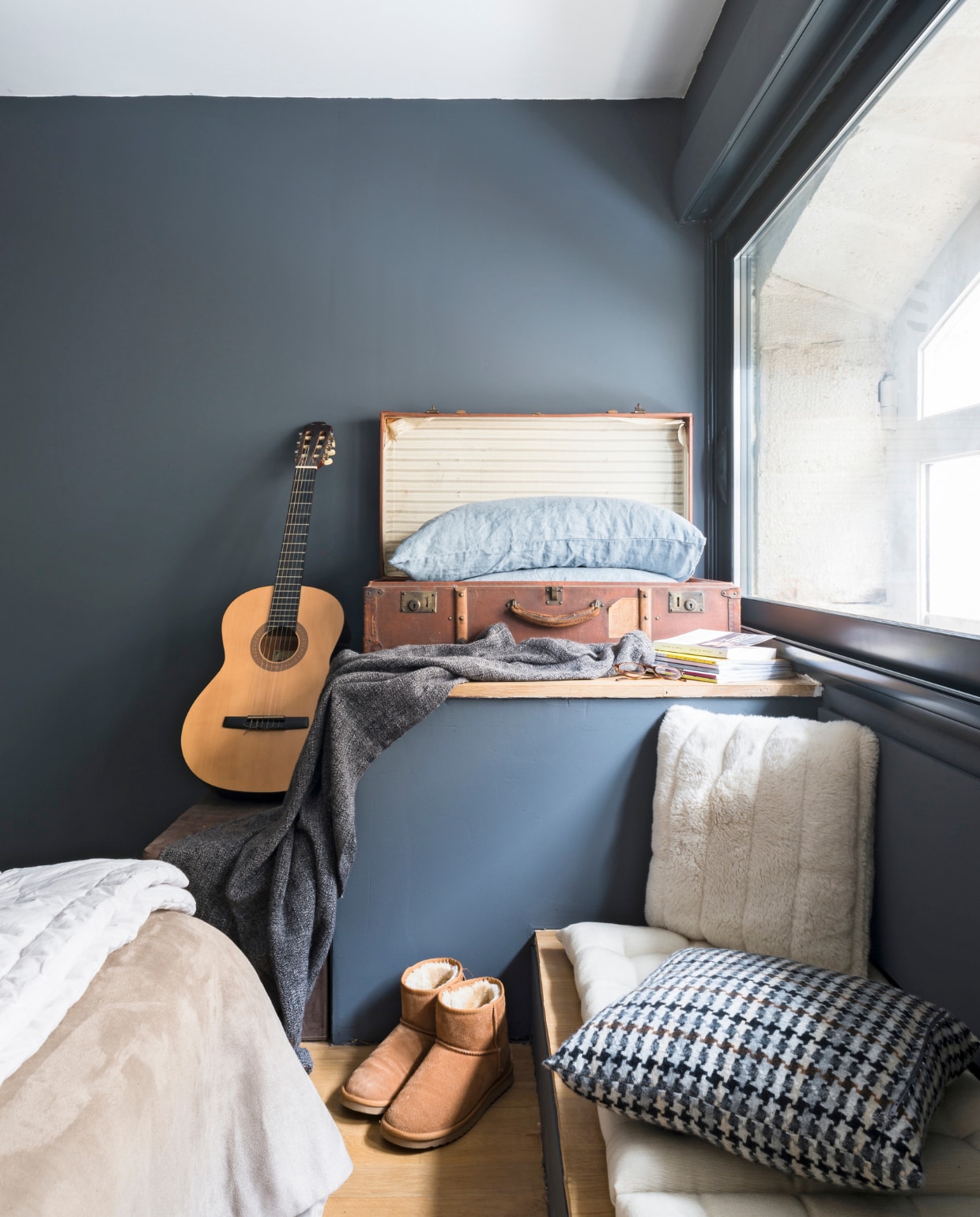 Een oude koffer uit de familie herbergt extra kussens. Het lage bankje is speciaal getimmerd als rustige gitaar-speel-plek. Het geblokte kussen is van www.madurahome.com vtwonen 03-2015 | Fotografie Julien Fernandez / amandinejules.com
