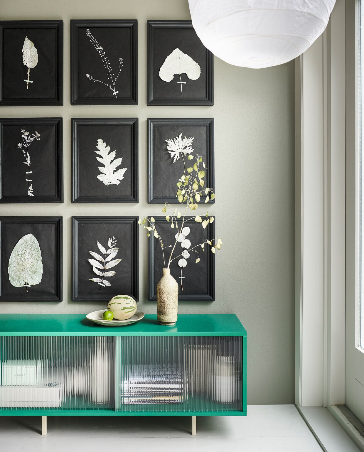 Muurverf Tempting Taupe van Lab Paint, per liter € 51,- (vestingh.nl). Lijst Edsbruk, 30x40 cm € 14,99, papieren lamp Rigolit, 45 cm (Ø) € 3,99 (ikea.nl). Kast Colour Cabinet M, hout, glas en staal, 120x39x51 cm (bxdxh) € 1299,- (hay.nl). Keramieken vaas € 98,-, keramieken schaal € 95,- (marjokedeheer.com). vtwonen special DIY 8 | styling Marianne Luning | fotografie Sjoerd Eickmans | realisatie Cobo&amp;Co