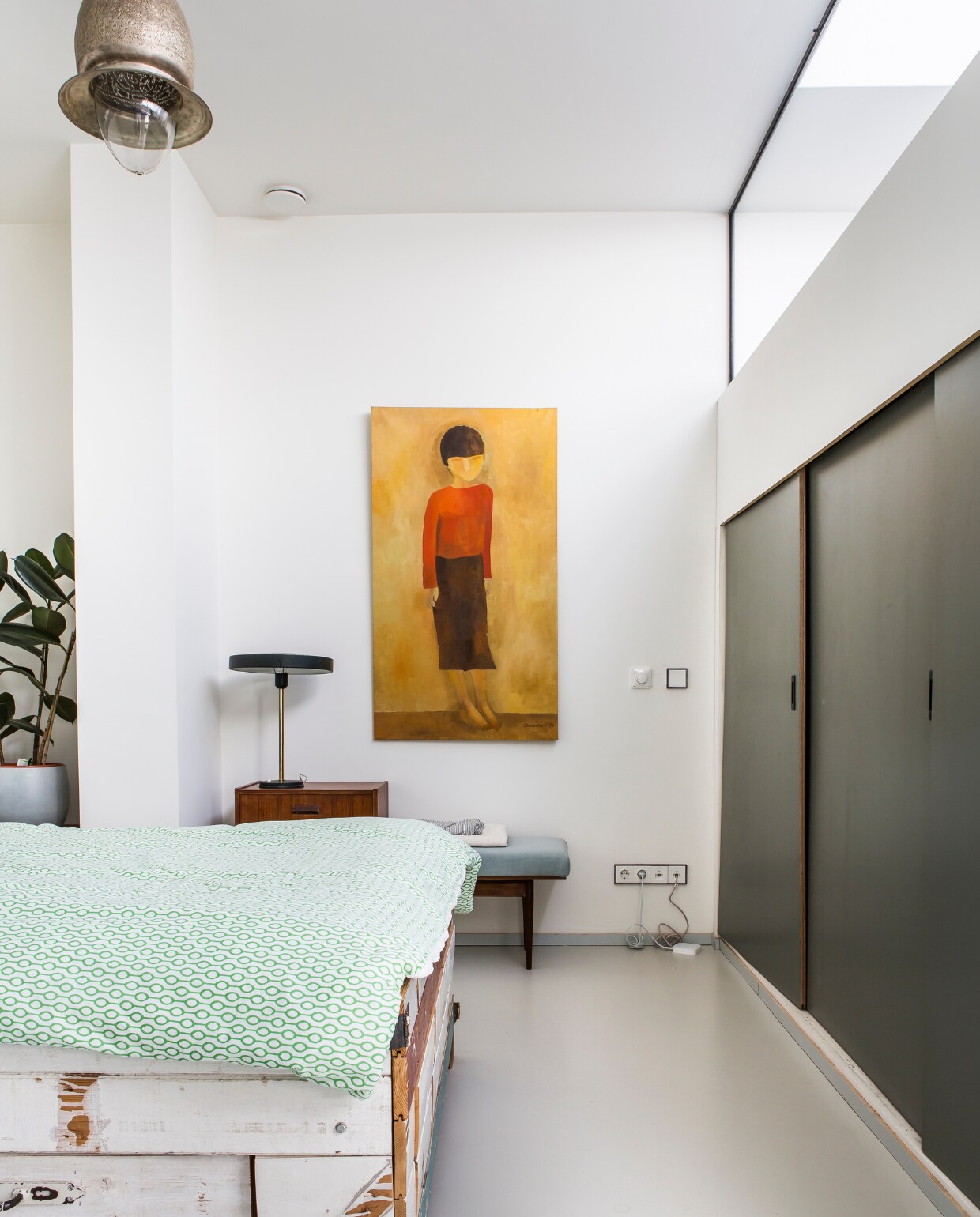 Peggy: ‘Ons bed hebben we laten maken door Roel Verhulst (www.roelverhulst.nl). Het telefoonbankje komt van de kringloop en heb ik zelf opgeknapt en gestoffeerd.’ Lamp Timor van Louis Kalff, schilderij van de vlooienmarkt in Waterloo, Oosterse lamp van Fanous Ramadan www.fanousramadan.nl, dekbedhoes van Ikea. De schuifdeur is op maat gemaakt door een timmerman en geverfd in de kleur betongrijs (RAL 7023). De ronde handgrepen komen van Weijntjes. vtwonen 04-2017 | fotografie Henny van Belkom