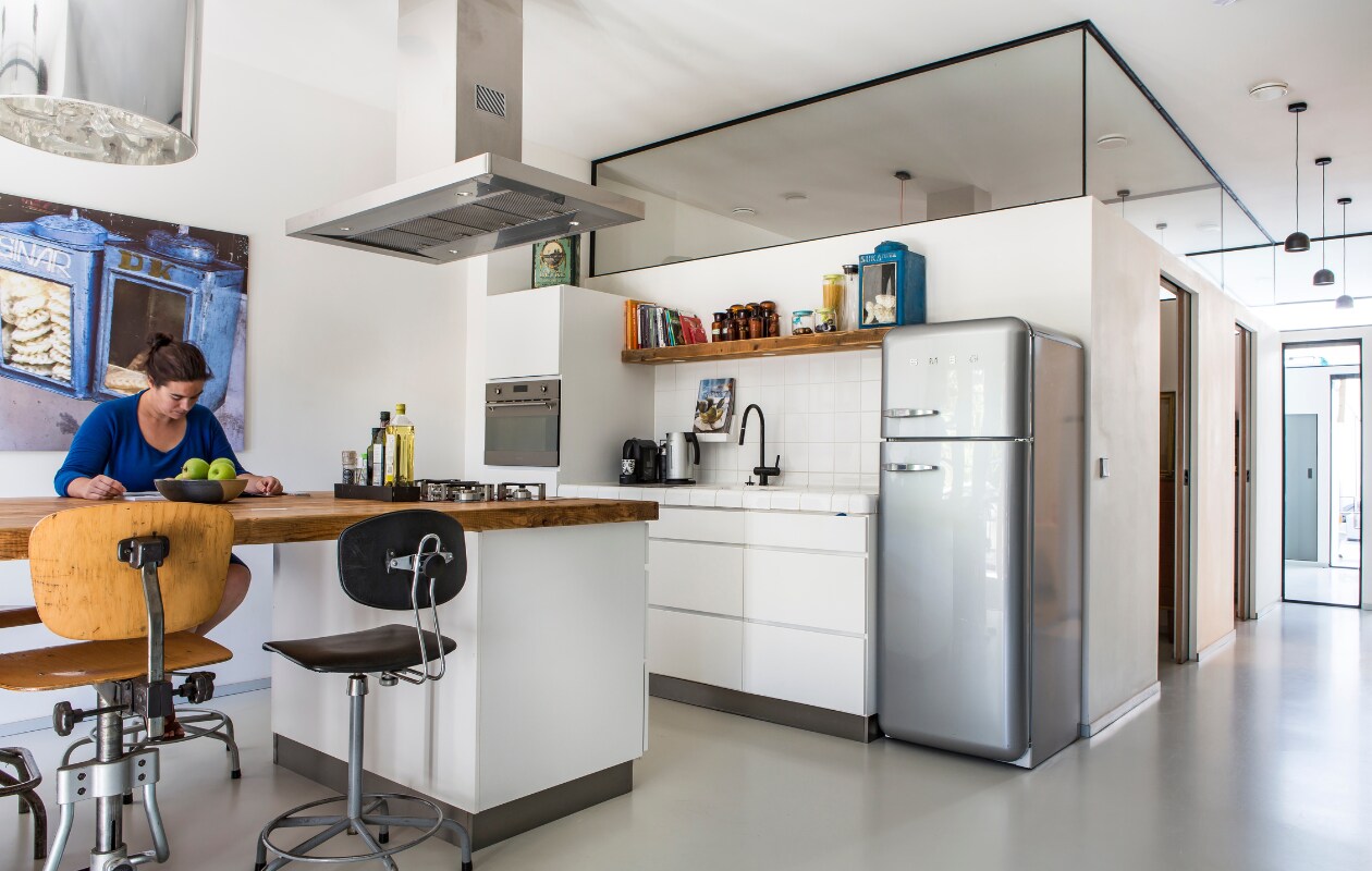 Keukenkastjes van Kvik, werkblad gemaakt door Van Joost, kookplaat en afzuigkap van Smeg. De gordijnen van oude legerdekens liet Peggy maken bij een naaiatelier op de Albert Cuyp. Barkruk Vivre, fruitschaal van de markt op het Vossenplein in Brussel, hanglamp (onbekend), plafondlamp van www.lamplord.nl. vtwonen 04-2017 | fotografie Henny van Belkom