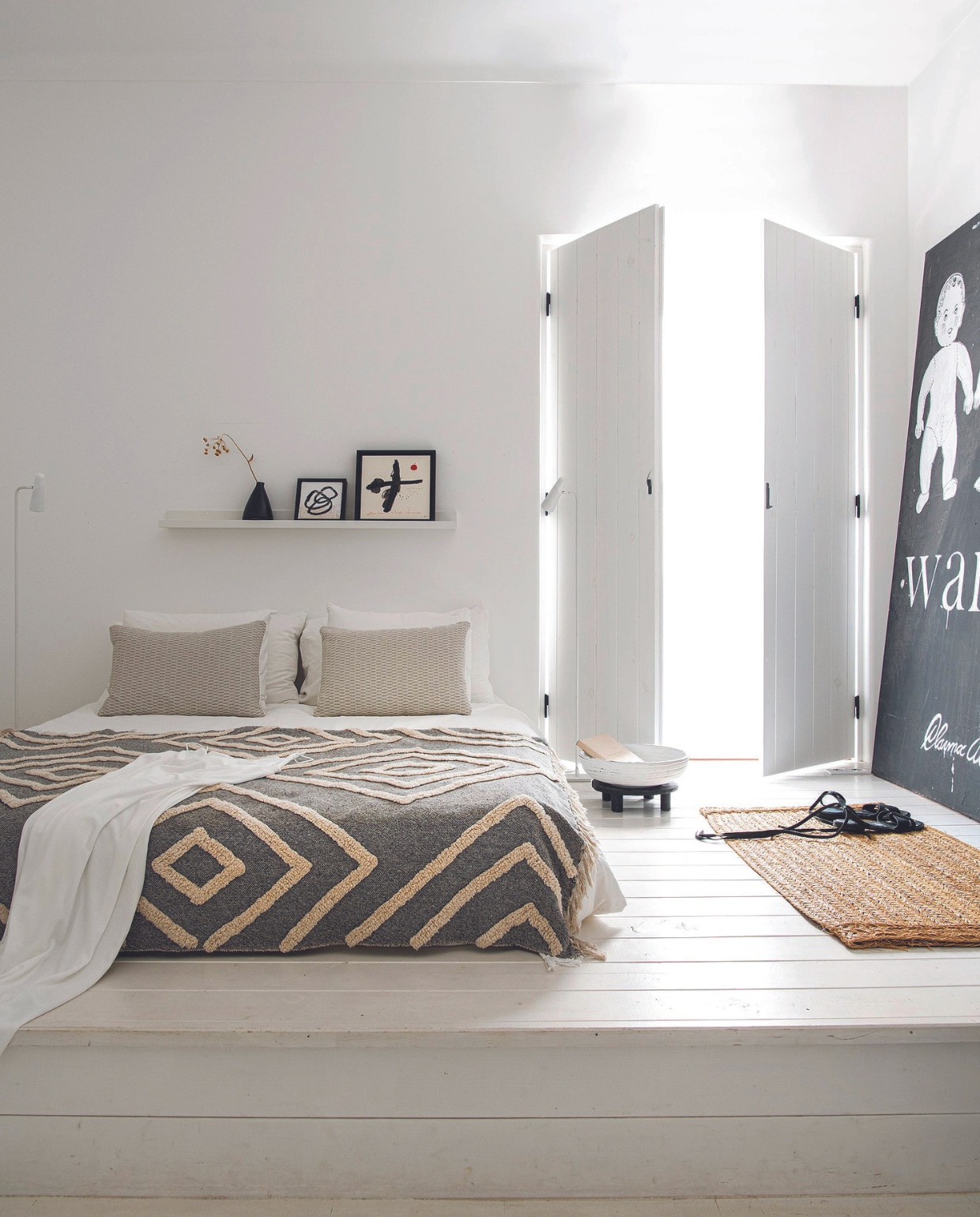 Sprei met motief en lage bijzettafel Casa. Schilderijen Eric de Bruijn. vtwonen 07-2024 | productie Inside Homepage | styling Anja Bas Backer | fotografie Louis Lemaire