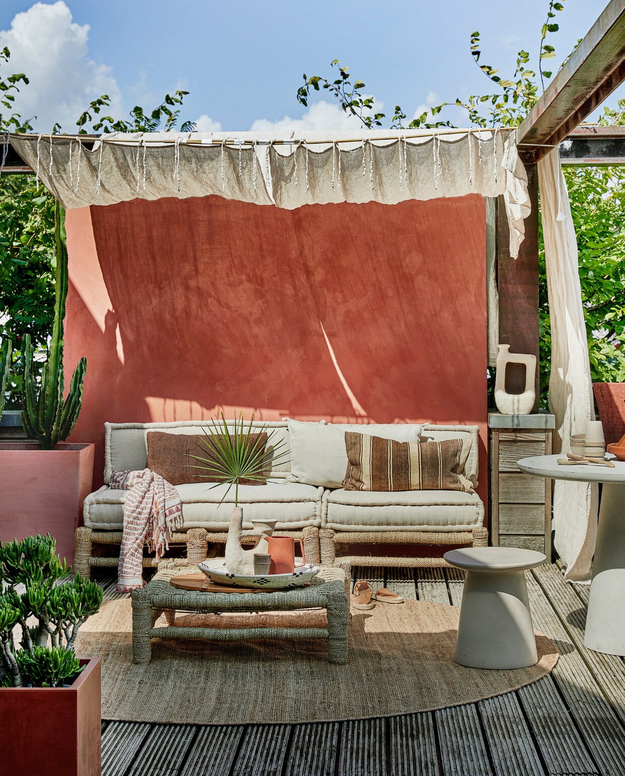 Met touw omwikkelde houten loungebank Hassan, 80x80 cm € 255,-, 120x80 cm € 335,-, zitkussens vanaf € 109,-, zandkleurige vaas Tamegroute met 2 armen € 109,-, zandkleurige vaas Tamegroute jerrycanvorm € 115,-, gevlochten schaal € 11,95, mokken en schaaltjes per stuk € 11,- (householdhardware.nl). Bruine sierkussens per stuk € 63,95, naturel geborduurd kussen Sabra Oblong XL € 99,- (zenzahome.com). Hennep vloerkleed, 250 cm (Ø) € 529,-, zandkleurige keramieken kruk Earthenware € 199,- (hkliving.nl). Espadrilles € 19,99 (hm.com). Fiberclay betonlook tafel Damon € 439,- (woood.nl). Terra karaf Flora € 21,95 (loods5.nl). Naturel linnen gordijnen Classic Sand, per stuk € 94,95 (casacomodo.nl). Hoge terra plantenbak Paris van Ecopots € 329,- (vtwonen.nl). Lage terra plantenbak € 45,- (intratuin.nl). Kalkverf op de muur kleur Marakech CC044, per liter € 52,80 (cartecolori.nl). Overig privébezit. vtwonen 08-2019 | styling Marianne Luning | fotografie Stan Koolen