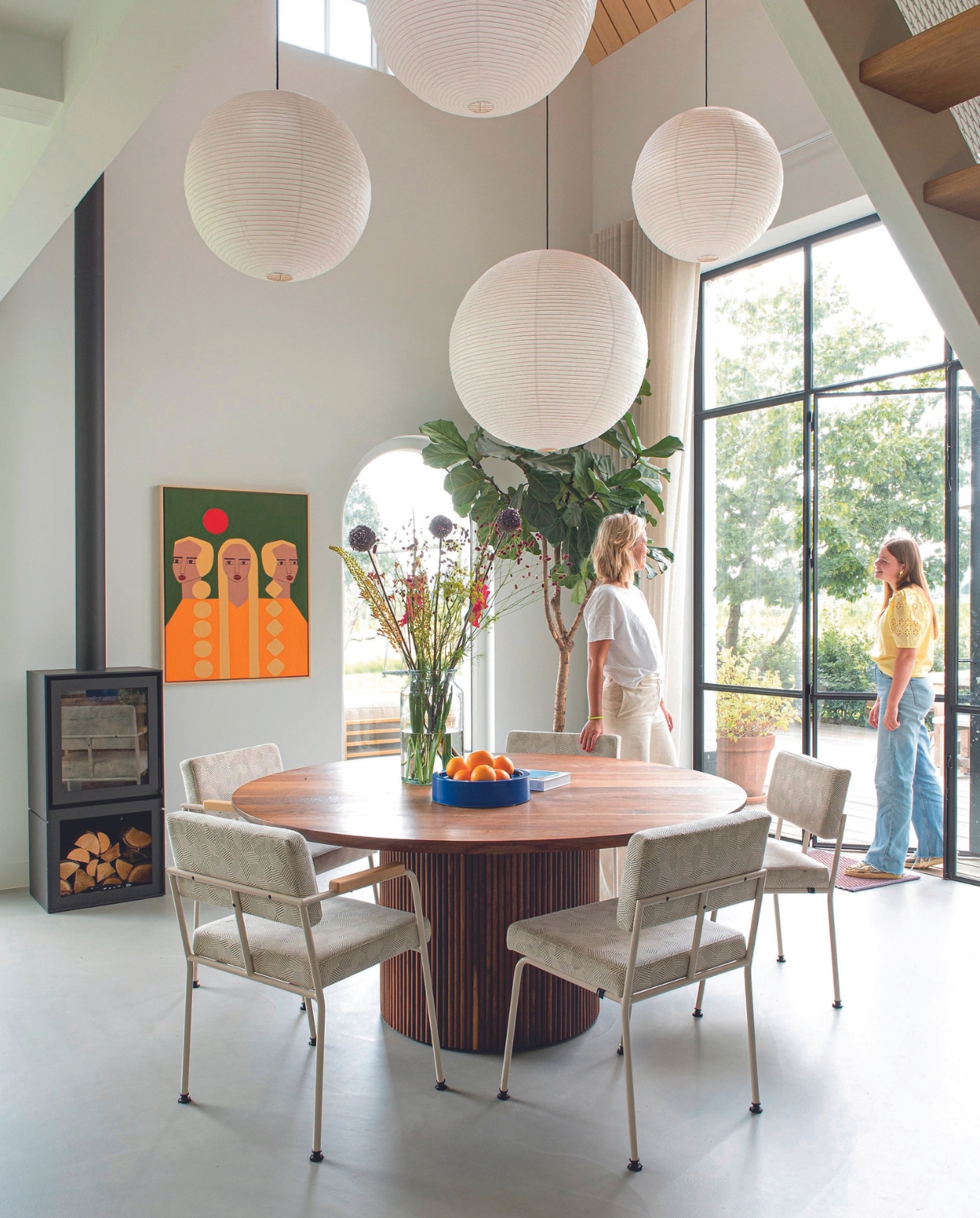 Vloer DRT Gietvloeren. Muurverf Ral 9016. Stalen pui Robert Staal, gordijnen Change Wonen, kachel Het Ambacht, eettafel Studio à la part. Eetkamer- stoelen en fruitschaal Fést. Plafondlampen Hay, schilderij Monique Rodríguez, plantenpot Ecopots. vtwonen 08-2024 | styling Jeske Weel | fotografie Caroline Coehorst