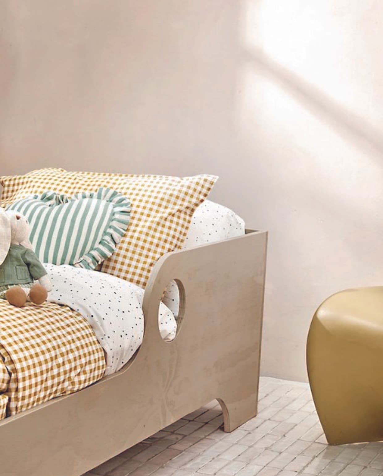 Juten vloerkleed van Ferm Living, 130 cm (Ø) € 69,-, papieren lampenkap Ellipse van Hay, 70x48 cm (Øxh) € 65,- rotan mand Eikel van Oyoy € 123,-, kussen in hartvorm € 39,99, oogmasker € 9,99, geel geblokt plaid, 130x180 cm € 69,99, wit velvet kussen € 29,99 (sissy-boy.com).Rieten mand € 59,99 speelgoedgitaar € 29,99,-, speelgoedbroodrooster € 29,99, bowlingspel € 22,99, speelgoedmuis op wielen € 12,99, houten regenboog € 22,99, stervormige nachtlamp € 15,99, stoffen knuffel haas € 22,99 (zarahome.com). Wit bolvormig kussen € 29,99, geel geruit dekbedovertrek, 140x200 cm € 24,99, dekbedovertrek met stippen, 140x200 cm € 24,99, opbergdoos € 9,99 (hm.com). vtwonen 08-2024 | styling Myla Griese | fotografie Louis Lemaire