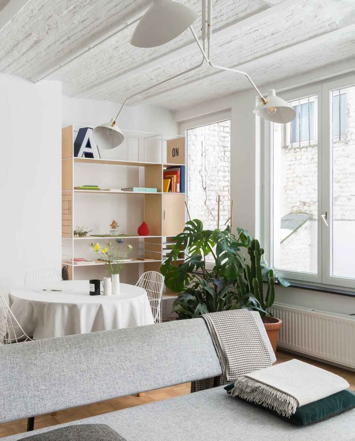 Kussen van Hay, plaid van By Mölle, poster van SB Studio, plant van Green Lifestyle store, stoel van Pastoe, boekenkast van Zuiver, vaas van Menu, spiegel van Kartell, kapstok van pt, zetel van Zuiver. vtwonen 12-2017 | styling &amp; fotografie Jonah Samyn | tekst Katrien Depoorter