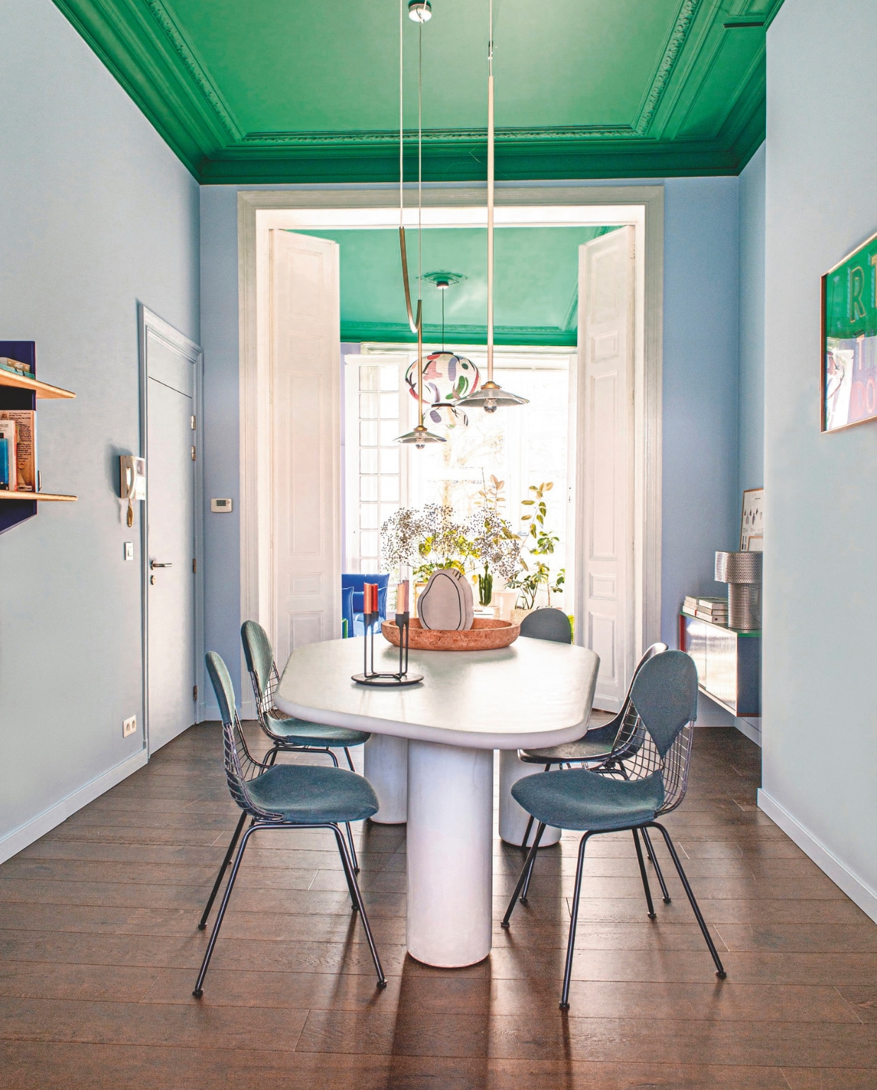 Wandrek Rayonnage Mural en stoelen Dkx van Vitra. Tafel La Grande Vézère van Armand &amp; Francine via La Fabrika, hanglamp Valerie Objects, vloer Cascada donker eiken van Quickstep. Plafondkleur In The Woods en wandkleur Surfers Blue uit de collectie Shade by Kelly van Shade vtwonen 09-2024 | styling Jeske Weel | fotografie Caroline Coehorst