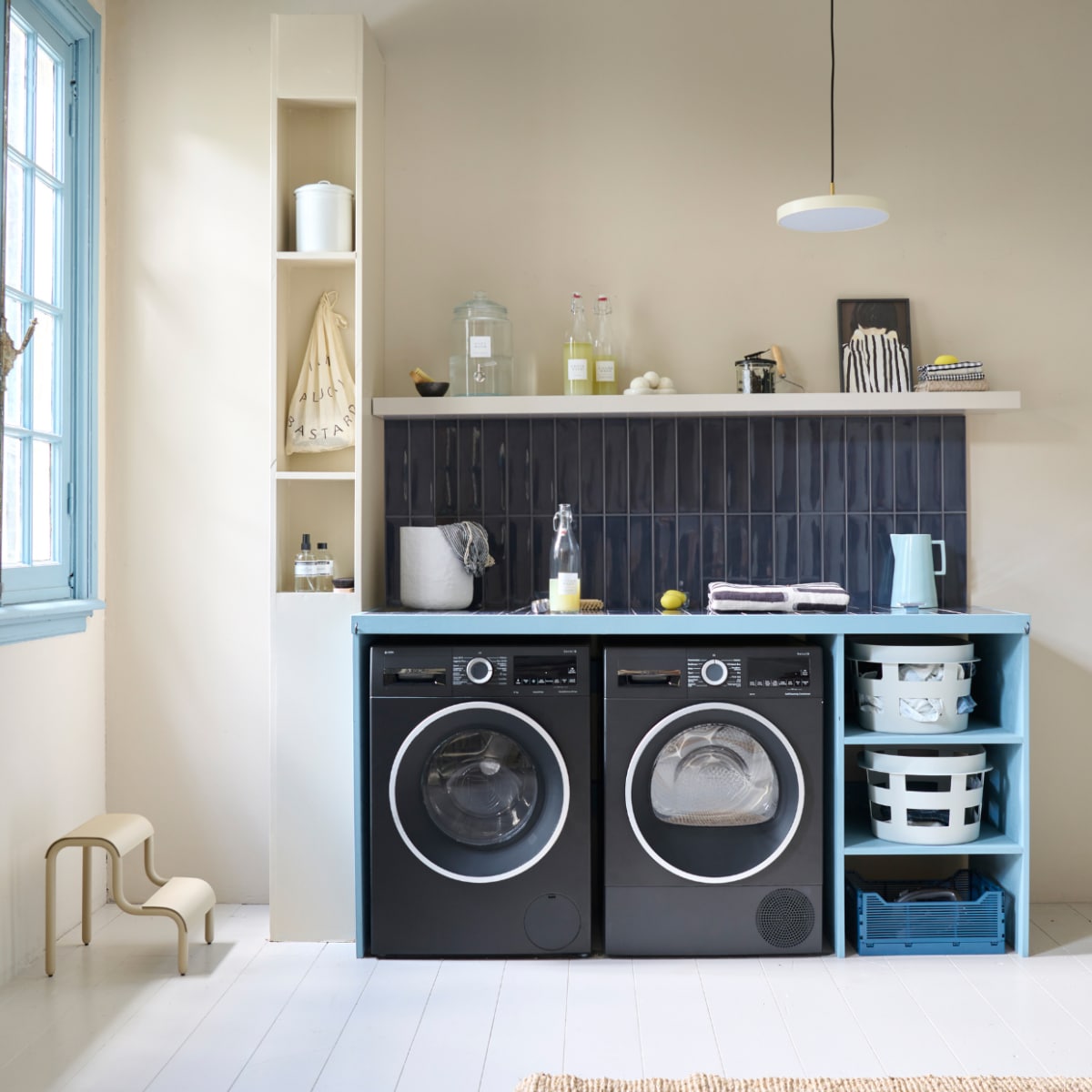 Lakverf wasbar Old Blue van vtwonen, 500 ml € 20,99, muurverf Warm White van vtwonen, 1 liter € 27,99 (karwei.nl). Lakverf kozijn Wit Golven, 500 ml € 30,99 (flexa.nl). Tegels Shapes van vtwonen in Titanium Blue Glans, 30x7,5 cm, per m2 € 59,- (go.vtwonen.nl/collectie)  Lamp Asteria van Umage € 179,45, kunststof wasmand van Hay € 39,-, metalen kruk van Ferm Living € 139,-, katoenen handdoek van HKliving € 49,-, katoenen mand van Ferm Living, set van 3 € 269,- (vtwonen.nl/shop). Emaillen blik € 9,95 (dille-kamille.nl). Wasmachine € 1069,-, warmtepompdroger € 1149,- (bosch-home.nl). Houten plank Lack € 29,99 (ikea.nl). Print Shy € 35,- (mydeerartshop.nl). Aardewerken kan Dik € 39,- (hollanddesignandgifts.com). Flessen linksonder in kast vanaf € 19,50 (marie-stella-maris.com). Flessen wasmiddel, pag. 44. Kleed Lohals, € 72,95 (ikea.nl), pag 34.Overig privébezit. vtwonen special DIY 8-2023 | styling Kelly van Gendt, Corrien Flohil | uitvoering Erik de Jong | fotografie Sjoerd Eickmans