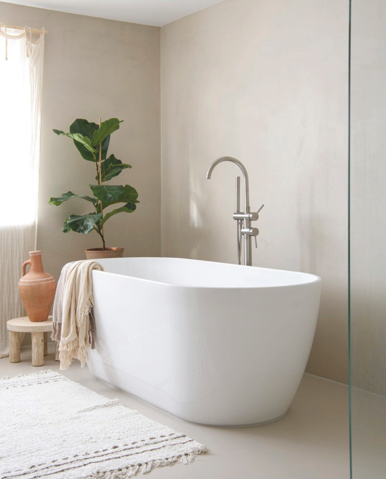 Muurkleur Beton Ciré zelf gemengd, gietvloer Gietvloerwinkel, bad Maxaro, kleed Søstrene Grene, bijzettafel Huis &amp; Grietje, kruik Loods 5, doek La Redoute, pot Esschert Design, plant Intratuin, badkraan Sanitairkamer. vtwonen DIY 9 | styling Janneke Peters | fotografie Louis Lemaire