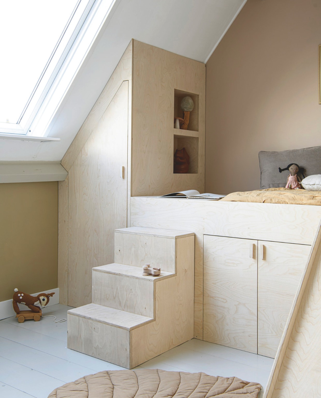 Muurverf links Sensational Sand van Lab Paint, muurverf rechts Arabic Desert Lab Paint, vloer vuren delen in Subtle Stone van Flexa Pure, bedstee met kasten en houten speelgoed op trap Huis &amp; Grietje. Kussens H&amp;M home en Karwei. Pop in bed Zara Home, bambi Sebra, kleed Lil’ Atelier. In de uitsparing: vilten paddenstoel Mushkane, houten paddenstoel Kleine Planeet, gieter eekhoorn Esschert Design. vtwonen DIY 9 | styling Janneke Peters | fotografie Louis Lemaire