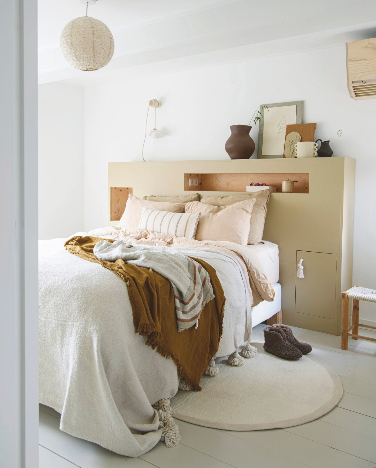Muurverf Ral 9016 van Sikkens, vloer vuren delen in Subtle Stone van Flexa. Lampionhanglamp, boomstamhaak en bedombouw Huis &amp; Grietje. Nachtlamp zelfgemaakt. Bed en bruine plaid Ikea. Beddengoed La Redoute, gestreept kussen Jysk, plaid met kwastjes Noa May, linnen plaid met strepen Juffrouw Jansen Lifestyle, kruk Leen Bakker, bruine vaas Piet Hein Eek voor Ikea, lijsten zelf gemaakt, witte vaas Loods 5, karaf kringloop. vtwonen DIY 9 | styling Janneke Peters | fotografie Louis Lemaire