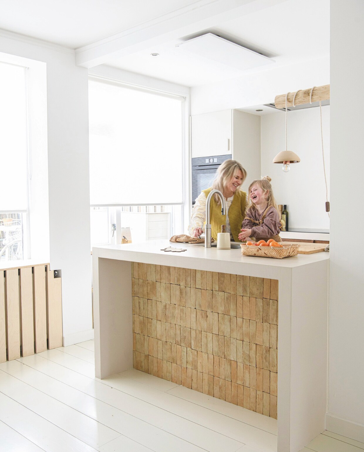 Keuken en onderzetter Huis &amp; Grietje. Muurverf Ral 9016 van Sikkens, vloer vuren delen, tegels keukenblok Designtegels, fruitmand Søstrene Grene, hanglamp zelfgemaakt van schaal, zeeppomp Xenos. vtwonen DIY 9 | styling Janneke Peters | fotografie Louis Lemaire