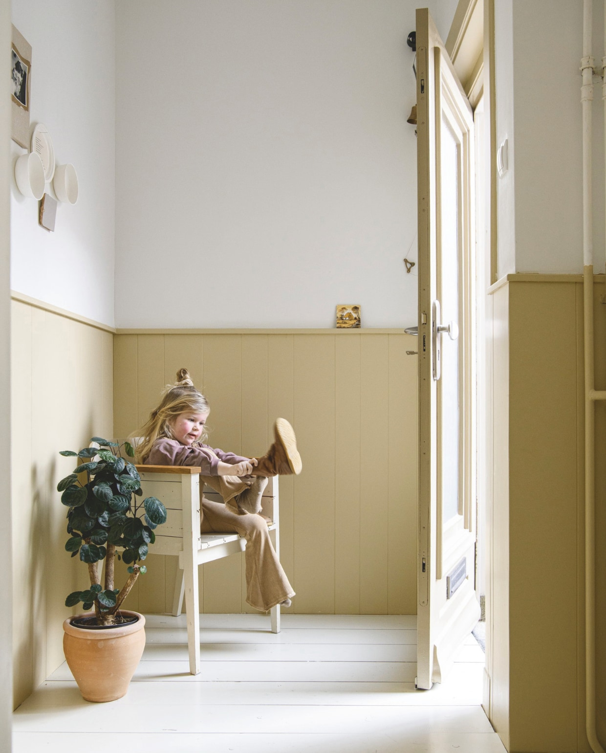 Muurverf Ral 9016 Sikkens, verf lambrisering Poffertjes van Gamma, borden aan de muur zelfgemaakt met foto’s, tegel souvenir uit Spanje, stoel Piet Hein Eek, pot Action, plant Intratuin. vtwonen DIY 9 | styling Janneke Peters | fotografie Louis Lemaire