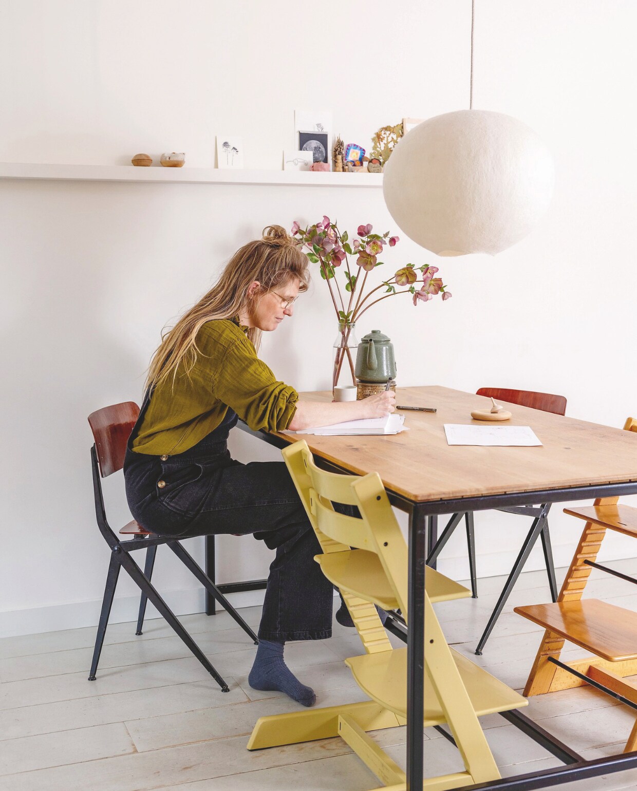 Plank aan de muur, tafel en houten tol zelfgemaakt. Lamp LumaLano, stoelen op straat gevonden, kinderstoelen Tripp Trapp van Stokke, theepot Dille &amp; Kamille. Vloer grenen planken, geverfd in Mizzle van Farrow &amp; Ball. vtwonen DIY 09 |  styling Ilona Jongepier | fotografie Dana van Leeuwen