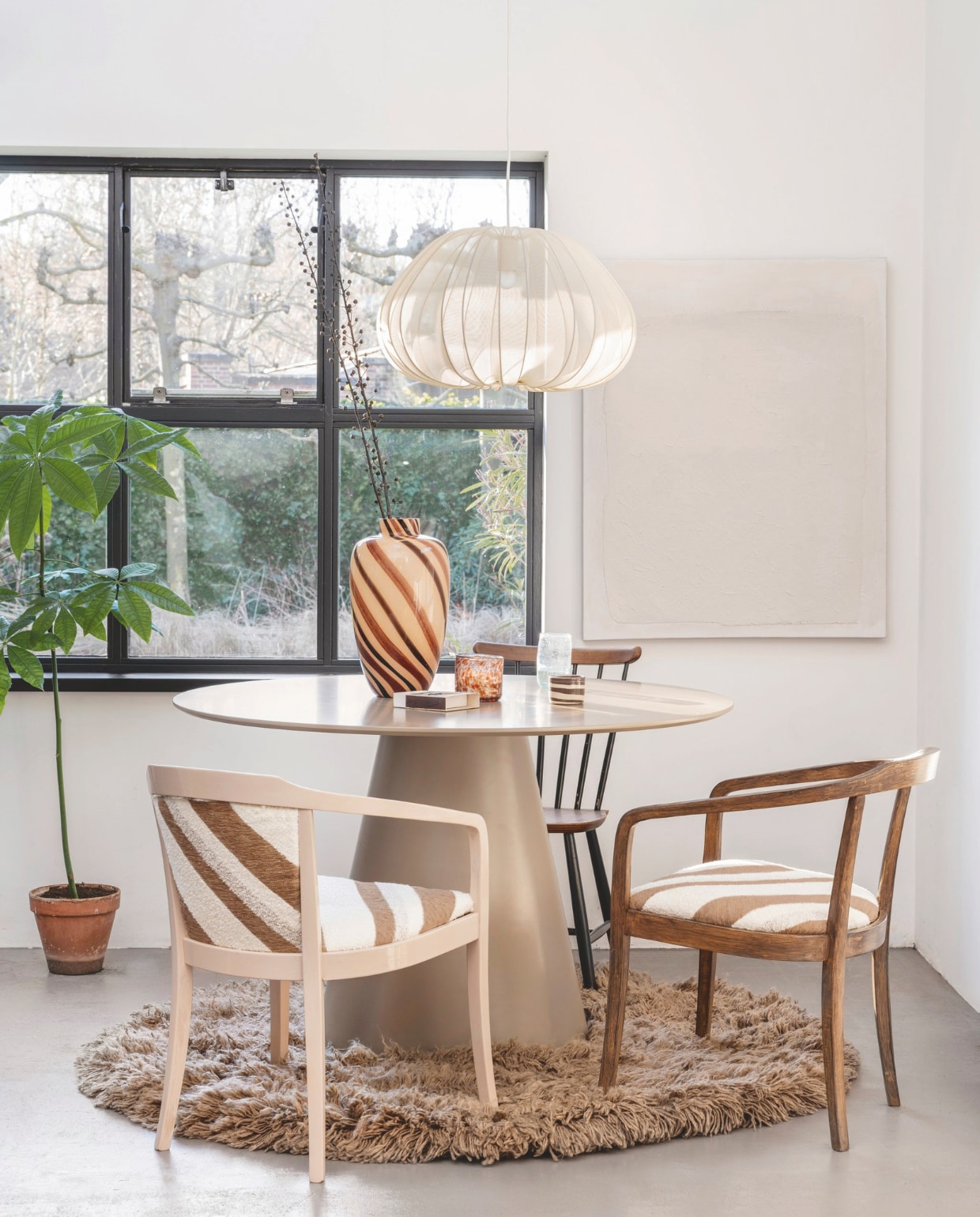 Stof Slalom, jacquard geweven chenille en bouclé, 140 cm breed, per meter € 111,60  (casamance.com). Linnen kunstwerk Maha, 89x102 cm (bxh) € 99,99 (kavehome.coml). Wollen vloerkleed Fluffy van HKliving, 150 cm (Ø) € 675,-, mdf tafel Jorre van Woood, 120x76 cm (Øxh) € 499,-, katoenen lamp Balloon van Bolia € 524,-, glazen vaas Affogato van HKliving € 99,- (vtwonen.nl/shop). Bruin-witte koffiekop € 24,- (studio-potterdam.com). vtwonen 09-2024 | styling Kelly van Gendt | fotografie Stan Koolen | m.m.v. de Kringloper Naarden