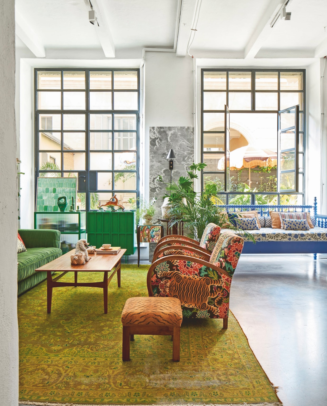 Perzisch tapijt, salontafel, poef, plantentafels vintage. Vintage stoelen bekleed met stof van Gastón y Daniela. Daybed, kleine kussens op het daybed, het beklede daybedmatras en accessoires op groene kasten Nap Atelier. Bank, groen dressoir, dressoir met geribbeld glas, effen en gestreepte kussens op het daybed en groen accessoire HKliving. Wandlamp House Doctor. vtwonen 09-2024 | styling Francesca Davoli | fotografie Fabrizio Cicconi