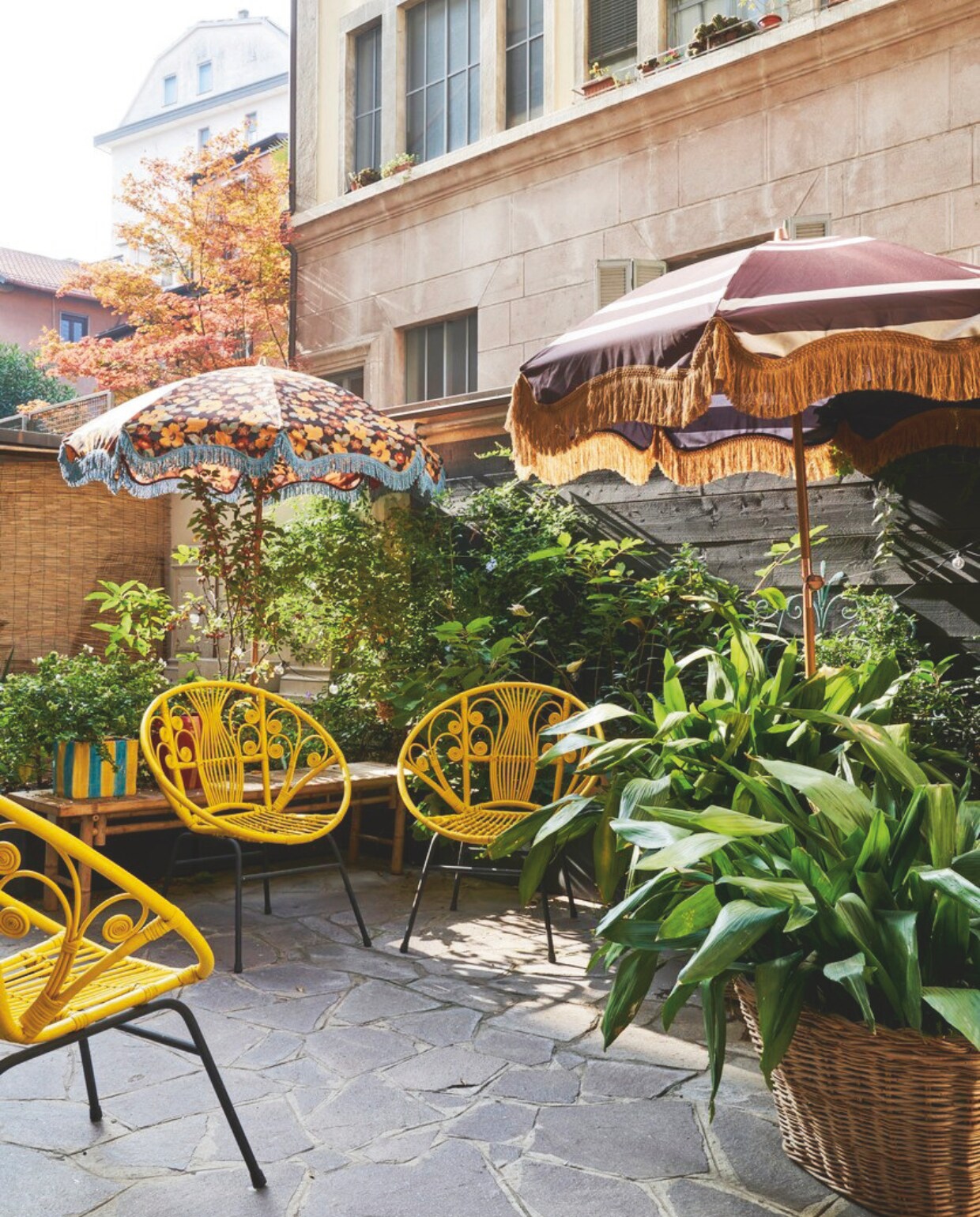 Vloerlamp en kussen HKliving. 2 Parasols HKliving, tuinstoelen Nap Atelier. vtwonen 09-2024 | styling francesca davoli | fotografie fabrizio cicconi