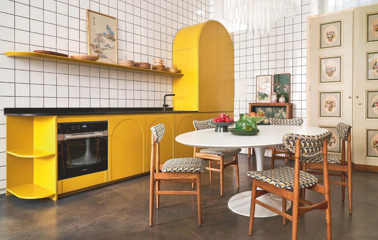 Keuken eigen ontwerp. Tafel en gestoffeerde stoelen Nap Atelier. Servieskast, kroonluchter en kunstwerken vintage. vtwonen 09-2024 | styling francesca davoli | fotografie fabrizio cicconi