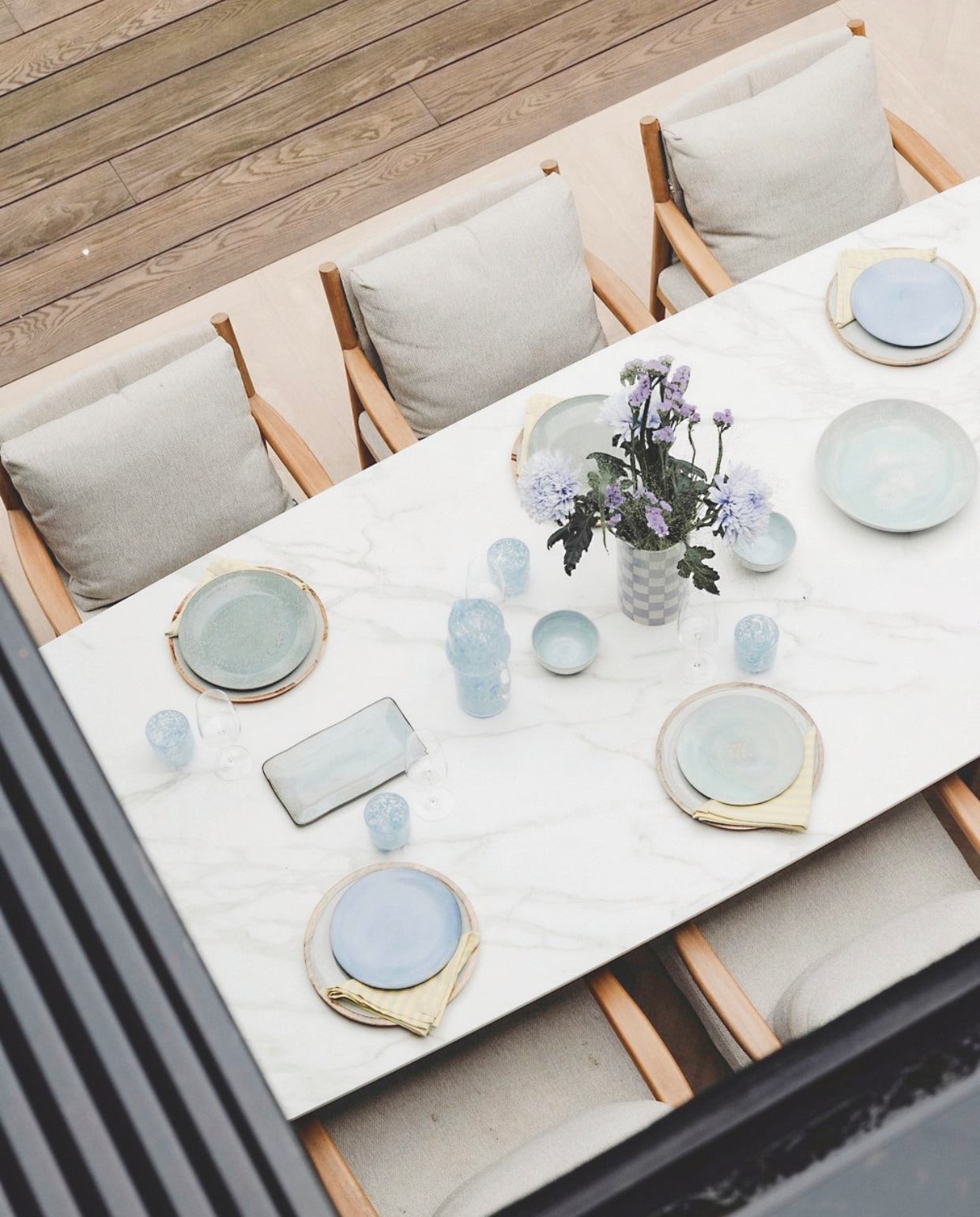 Lekker buiten eten aan de grote eettafel met acht stoelen van Kötter Living. De tafel met het marmeren blad en de stoelen zijn van Hello Suns. stijlvol wonen 9-2024 | Fotografie Stefanie De Neve