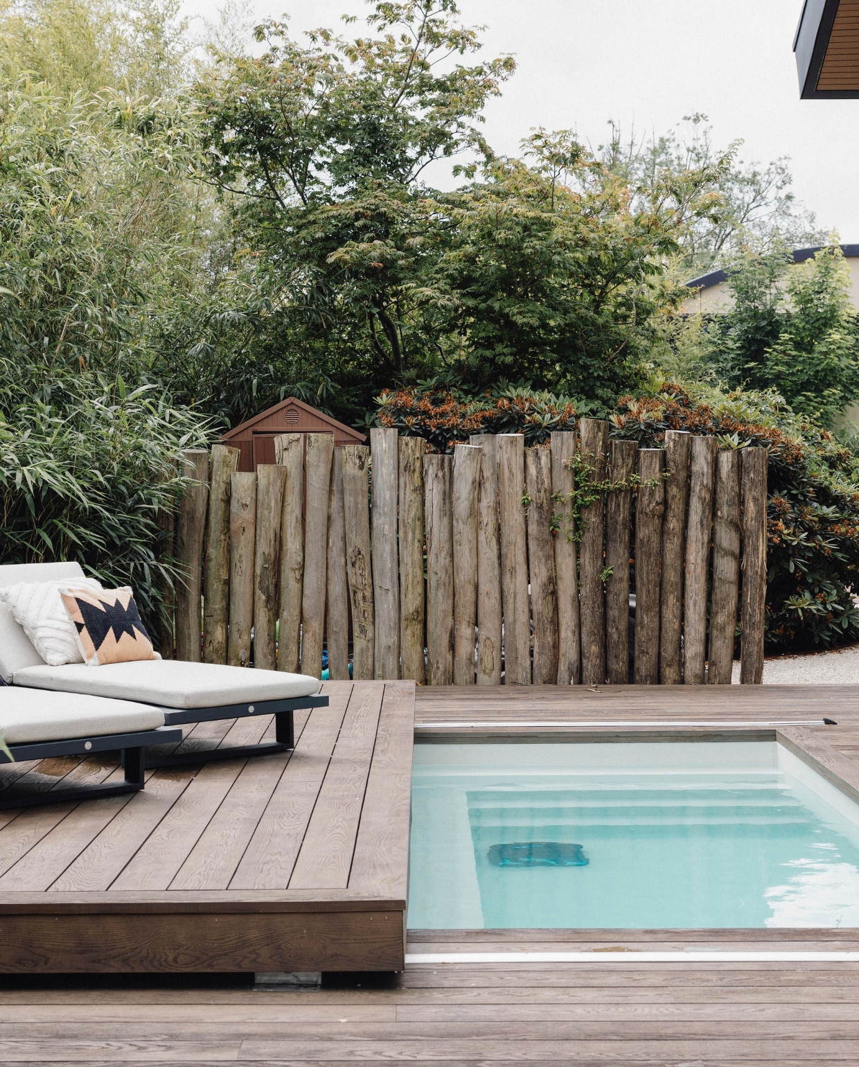 Naast het kleine zwembadje van Blaauw Mini Pools dat automatisch dicht kan worden geschoven, staan ligstoelen van Hello Suns met daarop kussentjes van Kötter Living. stijlvol wonen 9-2024 | Fotografie Stefanie De Neve