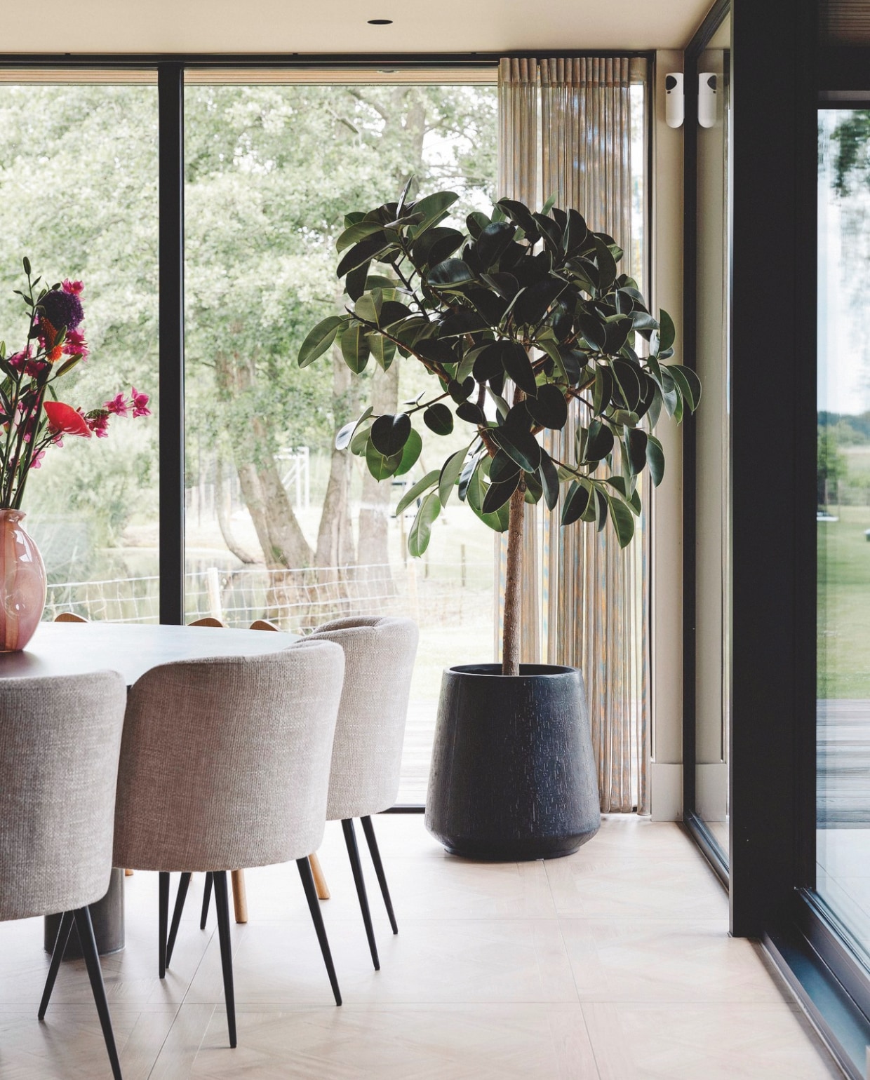Kobra Schilderwerken, met verf van Lab Paint. Op de vloer liggen tegels met houtmotief van Laurens Badkamers. Naast de stoelen van Kötter Living in de ontbijthoek staat een grote plant van plantenarchitect Jay and his Plants. stijlvol wonen 9-2024 | Fotografie Stefanie De Neve