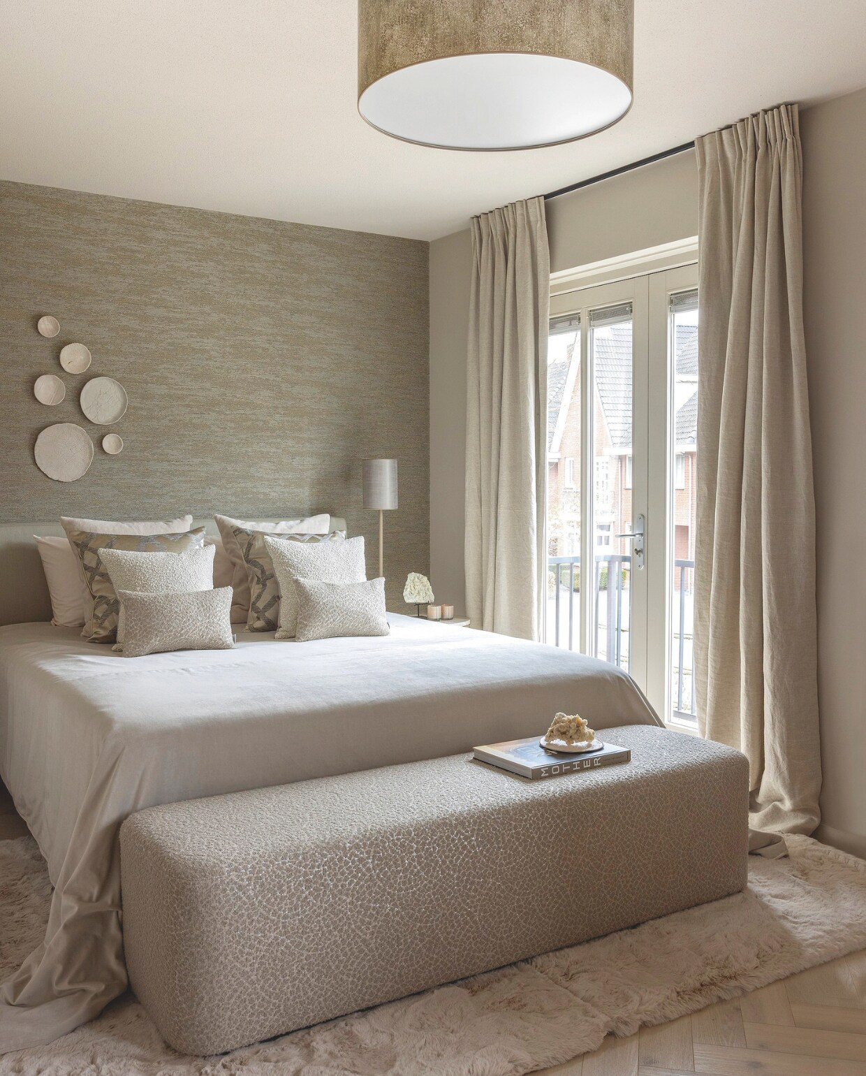 Het beddengoed van Douxe en de plaid zijn bij Violier at Home aangeschaft. Poef Verzino is van Hofstede Raanhuis, het carpet onder het bed is van het eigen label van Violier at Home. De plafondlamp en nachtkastjes zijn van Duran Interiors . De lamp op het nachtkastje is van By Eve. Op de achterwand is gekozen voor behang van Casamanche, de bordjes aan de muur zijn van kunstenares José van Alfen van Natural Art. Alles is geleverd door Violier at Home. stijlvol wonen 10-2024 | Foto Anne Gambon