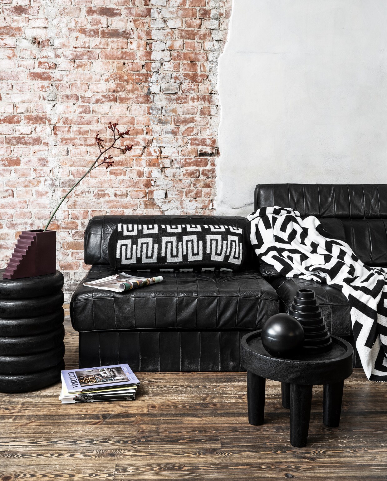 Zwart-wit rond kussen, gebreid bci-katoen, 20x50 cm € 49,95, zwart-witte plaid met verschillend dessin aan beide kanten, gebreid bci-katoen, 130x170 cm € 99,95, zwarte metalen vaas, 20x20 cm (Øxh) € 34,95. Overig privébezit. vtwonen 10-2023 | huiscollectie