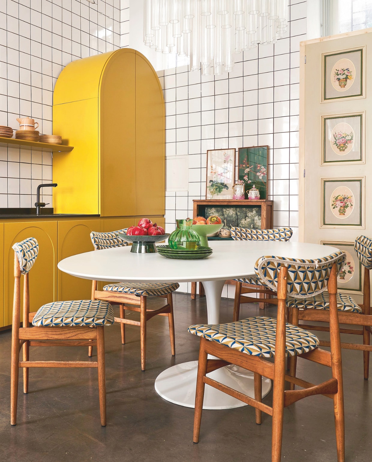 Keuken eigen ontwerp. Tafel en gestoffeerde stoelen Nap Atelier. Servieskast, kroonluchter en kunstwerken vintage. vtwonen 09-2024 | styling Francesca Davoli | fotografie Fabrizio Cicconi