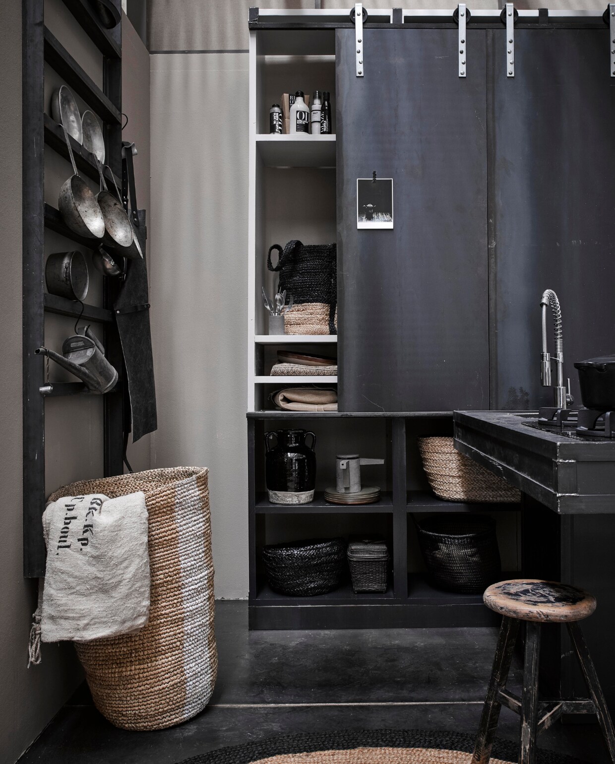 Styling beeld, zwarte keuken, mand met witte streep, roldeur buffetkast, barkruk, vtwonen 03-2017 | styling Marianne Luning | fotografie Alexander van berge