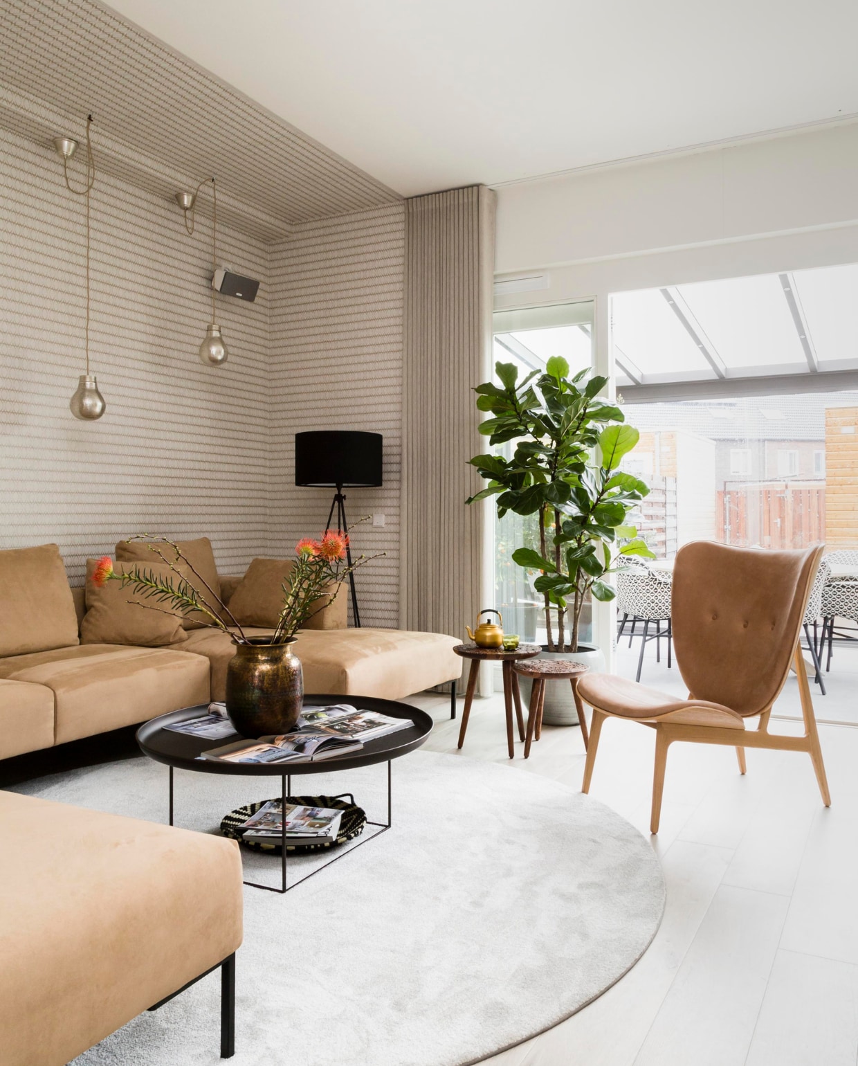 Koperkleurig behang Lounge art.nr. 388710 per rol € 69,95 (eijffinger.com). Vloerkleed ø 250 cm uitvoering 2605-605 € 1256,25, loungestoel Elephant van Nor11 75x80x96 (bxdxh) zithoogte 38 cm € 1.799,-, bijzettafel By Hand M van Dutchbone 35 cm € 149,-, bijzettafel By Hand L van Dutchbone 40 cm € 165,- (eijerkamp.nl). Gordijnen van Inspire met een wave-plooí Gloed kleur 180 Mushroom per meter € 79,50 (woninginrichting-aanhuis.nl). Vaás 30 cm Bahia van Dutchbone € 55,-, boek Home €24,99, boek Stylen in 1 dag € 5,95, zwarte staande lamp Lesley van Zuiver € 149 (vtwonen.nl). Glázen met waxine erin per stuk € 5,50 (madamstoltz.dk). Theepotje € 16,50, glaasje met waxine € 4,50 (householdhardware). Boom Ficus Lirata (verkrijgbaar bij de betere tuincentra). Plantenpot € 69,95 (osdorp.nl). vtwonen weer verliefd op je huis 10 | styling Frans Uyterlinde | fotografie Barbara Kieboom