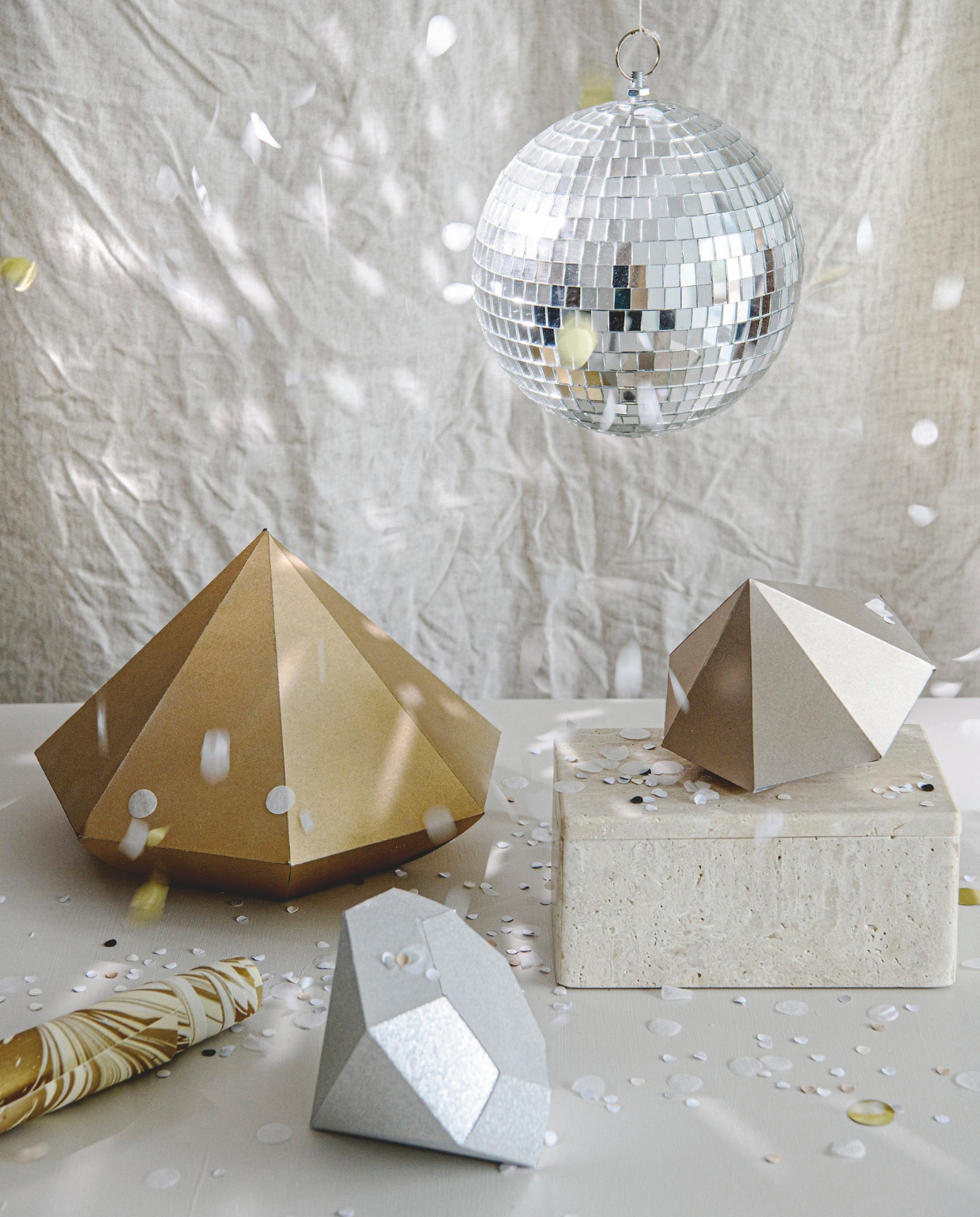 Discobal 20 cm (Ø) € 7,20 (partywinkel.nl). Rol gemarmerd papier € 3,50 (zaanschfaamwebshop.nl). Confetti in  Kraft, Wit en Goud € 4,95 (partydeco.nl). Marmer-travertin opbergbakje, 12x12x8 cm (lxbxh) € 39,99 (zarahome.com). vtwonen 10-2024 | styling Myla Griese | fotografie Louis Lemaire