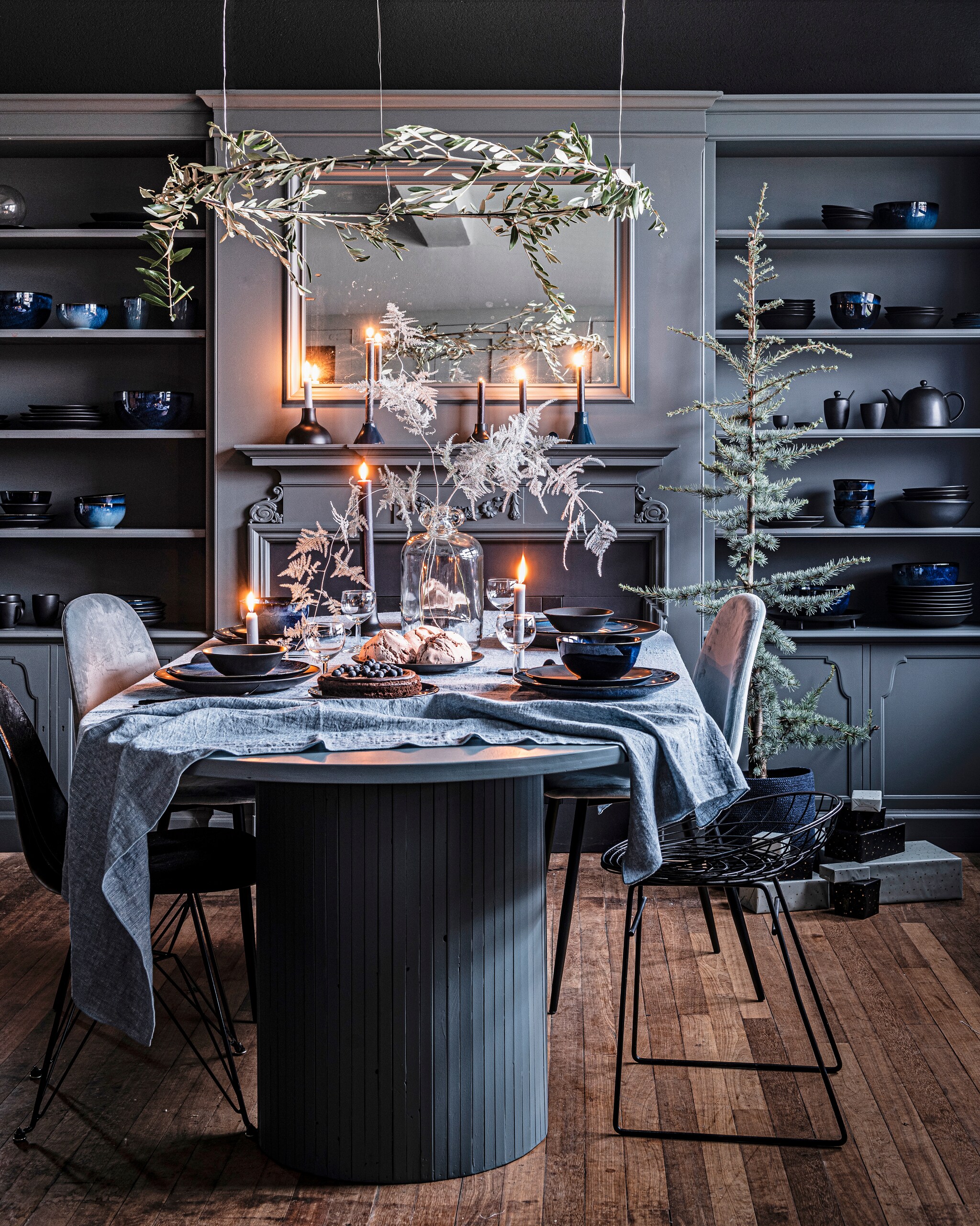 Donkerblauw porseleinen servies, 16-delig € 99,-, ook verkrijgbaar als losse onderdelen vanaf € 3,95. Matblauw porseleinen servies, 16-delig € 99,- of 36-delig € 239,-, ook verkrijgbaar als losse onderdelen vanaf € 4,50. Matzwart porseleinen servies 16-delig € 99,- of 36-delig € 239,-, ook verkrijgbaar als losse onderdelen vanaf € 1,95. Diverse metalen kandelaars zwart en donkerblauw vanaf € 8,95. Glazen vaas 22×31 cm (Øxh) € 69,95. Linnen tafelkleed, 150×250 cm (bxl) € 79,95. Zwarte ornamenten ring 100 cm (Ø) € 24,95, ook in formaat 80 cm (Ø) € 19,95. vtwonen 12-2021 | productie Tanja Saarberg | styling Kim van Rossenberg | fotografie Sjoerd Eickman
