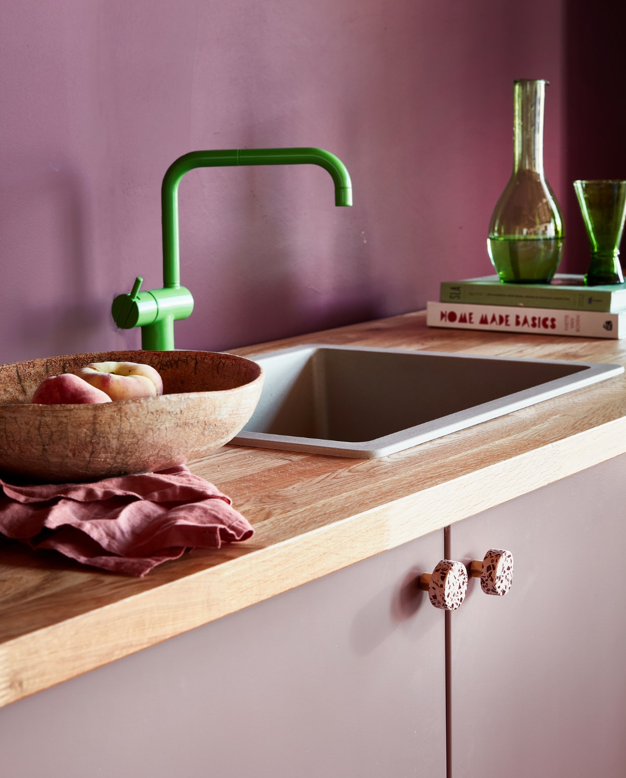 Muurverf Flexa Easycare Keuken kleur Bordeaux Leaf, per liter € 25,49 (Flexa). Caramelkleurige spoelbak € 374,- (Frontz). Groene monoknop mengkraan kv1-06 € 1140,- (vola.com). Aanrechtblad Karlby € 139 (ikea.be). Schaal € 8,- (Het Goed). Linnen servet, set van 2 € 9,99 (hm.com). Kookboek Homemade Basics van Yvette van Boven € 34,99, kookboek Sla, Easy Salades € 27,- (bol.com). Groene glazen karaf € 32,-, groen conisch glas € 7,25 (householdhardware.com). vtwonen 09-2022 | styling leonie Mooren | fotografie Peggy Janssen
