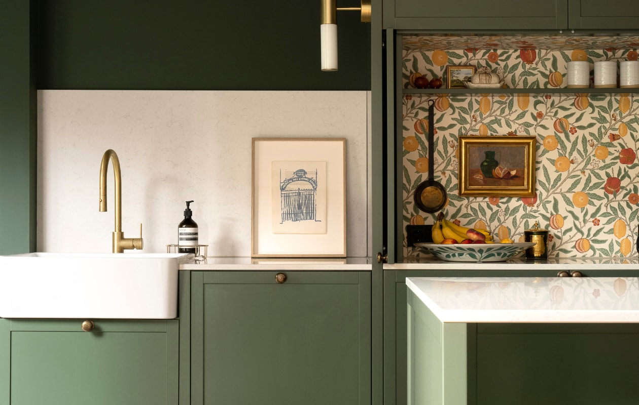 Een dun aanrecht op een groene keukenblok in de kleur Duck Green van Farrow &amp; Ball.  Vrolijke behang van William Morris (Morris &amp; Co).Architect: Sies Home Interior Design Uitvoering: Justustjebbo vtwonen verbouwen 4-2023 | fotografie Justus Felthuis