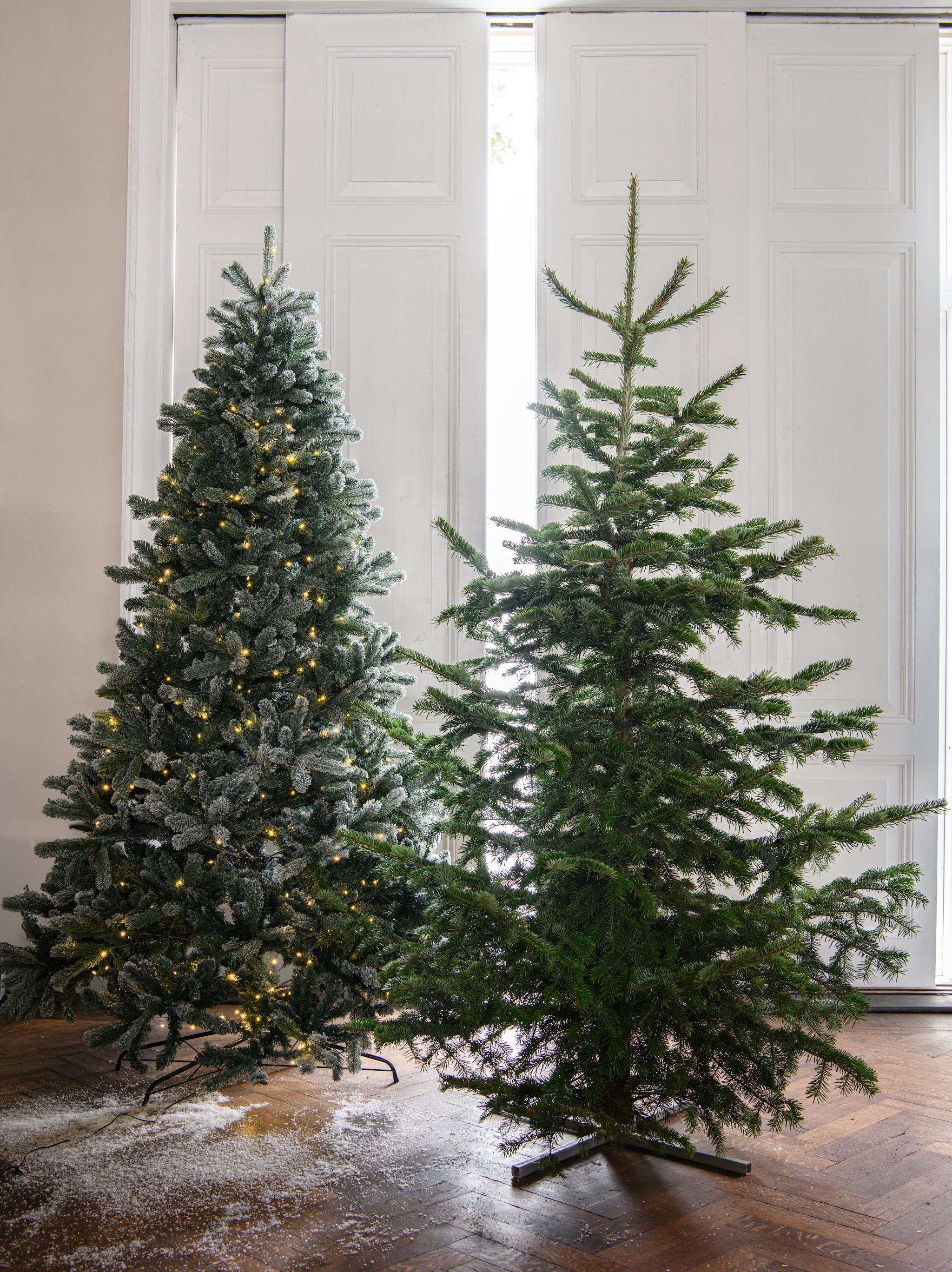 Sfeer &amp; DIY 4x kerstboom | Links: Kunstkerstboom Anton Snowy, voor binnen en buiten, inclusief ledlicht, 152x240 cm (Øxh) € 490,- (sirius.dk), Rechts: Natuurlijke kerstboom Nordmann, 240 cm (h) € 55,- (buitengoeddeboomgaard.nl) vtwonen 12-2024 | styling Marit Saladini | fotografie Louis Lemaire