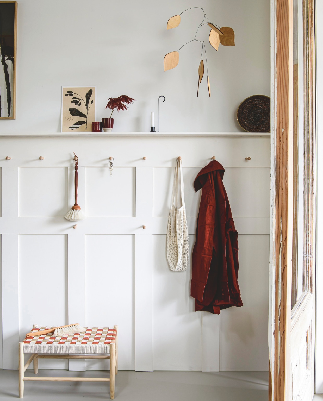 Essenhouten bank met gevlochten zitting, 50x28x28 cm (bxdxh) € 89,99 (zarahome.com). Geitenharen stofborstel/pluim € 34,-, geitenharen stoffer € 22,- (thefinestore.com). Gietijzeren kandelaar Lykta € 22,50 (bymolle.com). Hoge keramieken mok Rutunda € 12,90 (mykinta.com). Rode keramieken beker € 4,99, linnen overhemd € 29,99 (hm.com). Print Botanical Garden € 23,92 (shinachoi.com). Nettas € 7,95 (dille-kamille.com). Art print Shy van Maaike Koster, 50x70 cm € 199,- (mydeerartshop.nl). Houten mobile van Kinetic Levi privébezit. vtwonen special DIY 03-2024 | styling Myla Griese | fotografie Louis Lemaire